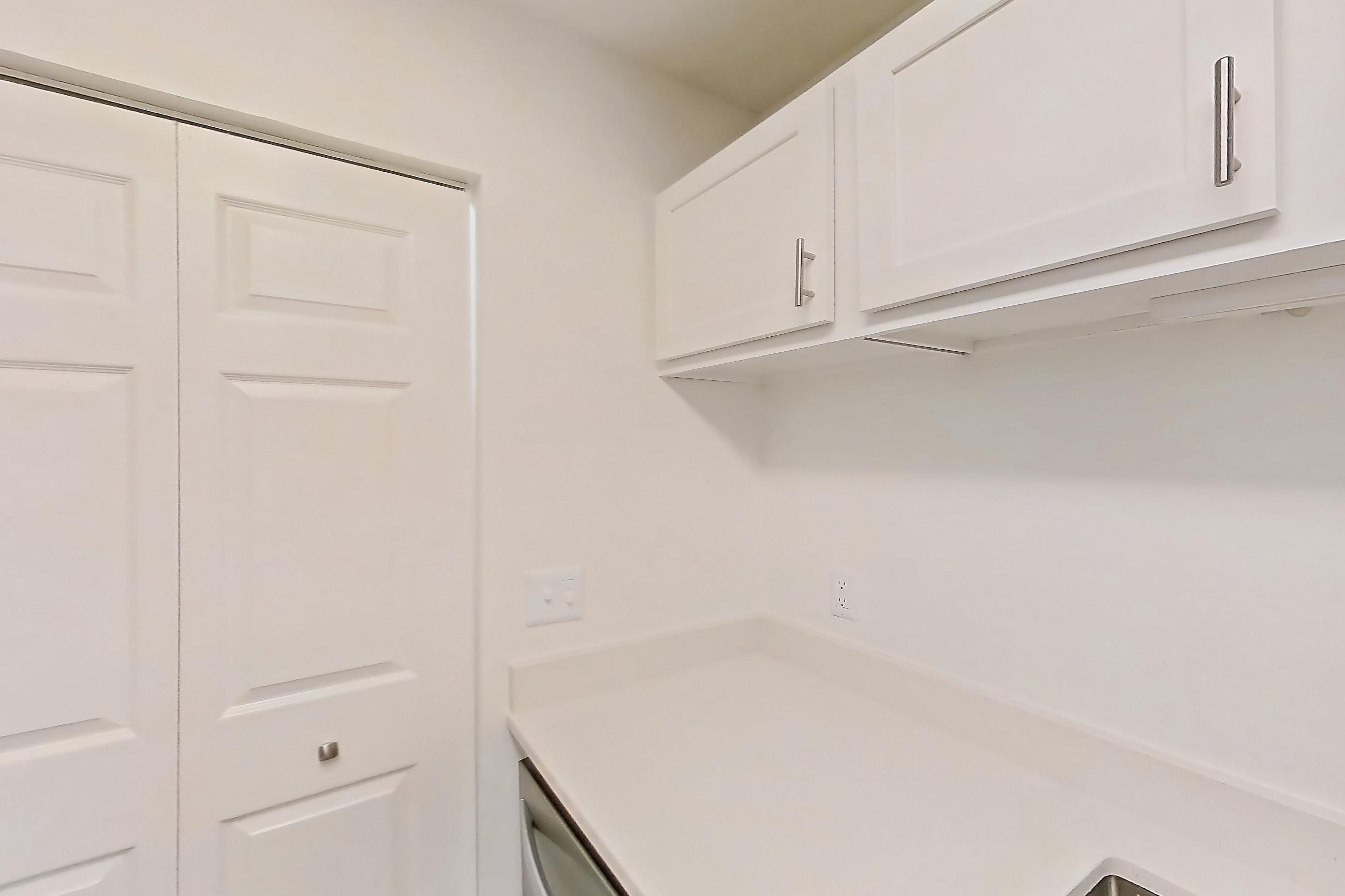 Kitchen with dishwasher, electric range, light countertops, light wood-finish flooring, oven/range, refrigerator, and stainless steel appliances, Apartment 61-B08 at Crosstown at Chapel Hill
