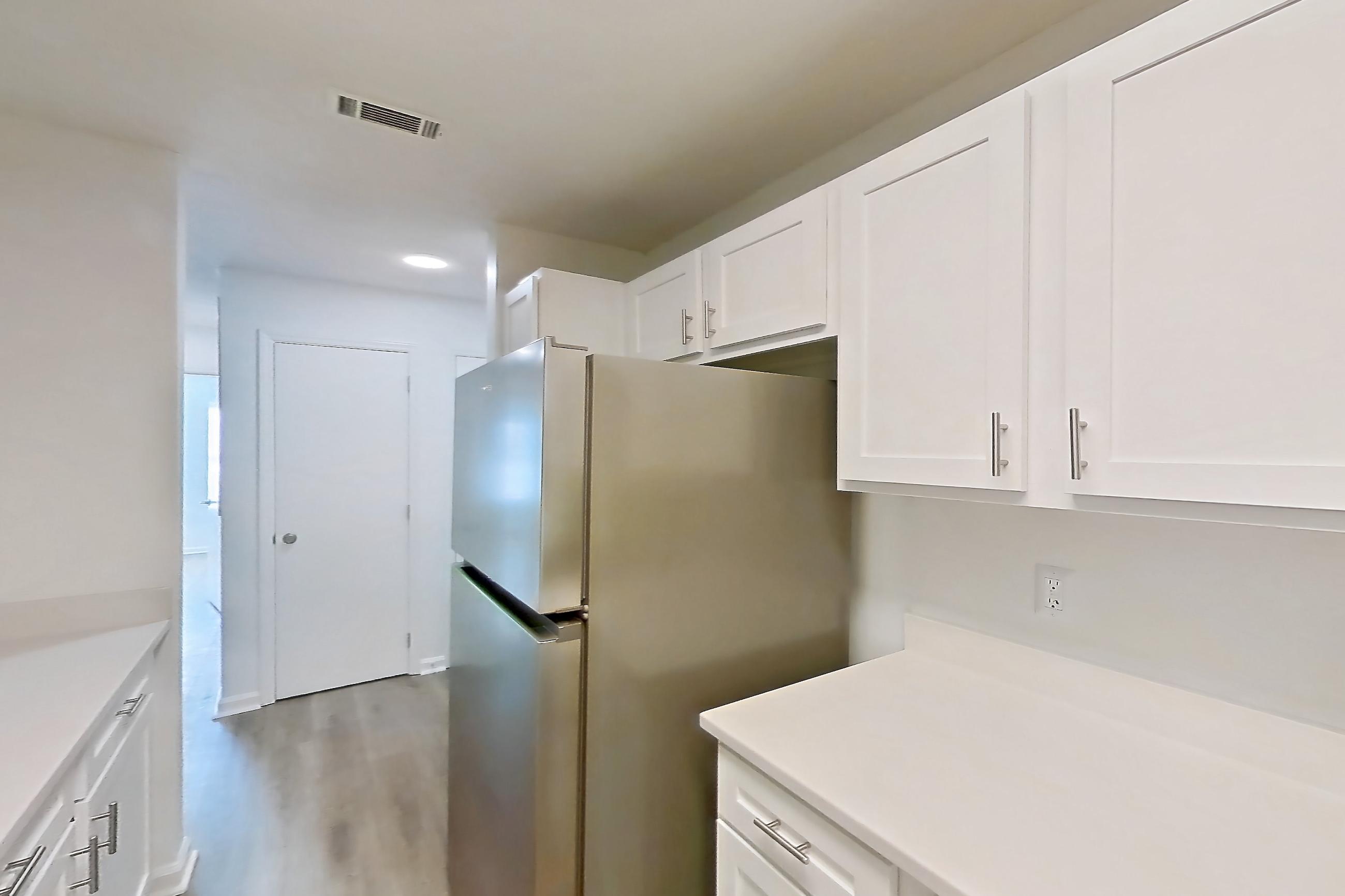 Kitchen with dishwasher, electric range, light countertops, light wood-finish flooring, oven/range, refrigerator, and stainless steel appliances, Apartment 61-B08 at Crosstown at Chapel Hill