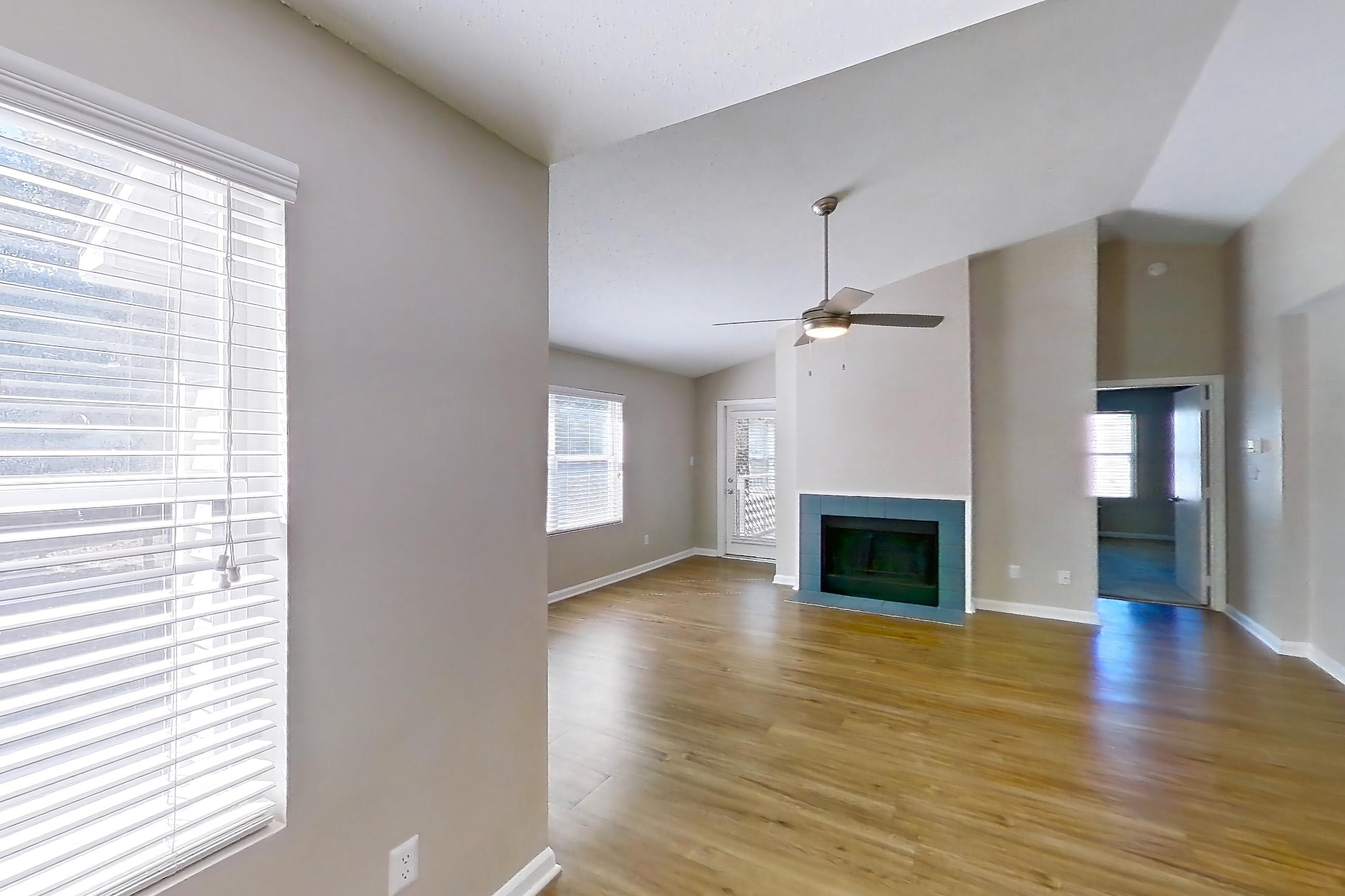 Dining room with black appliances, electric range, fireplace, light wood-finish flooring, oven/range, and tile fireplace, Apartment 61-I08 at Crosstown at Chapel Hill