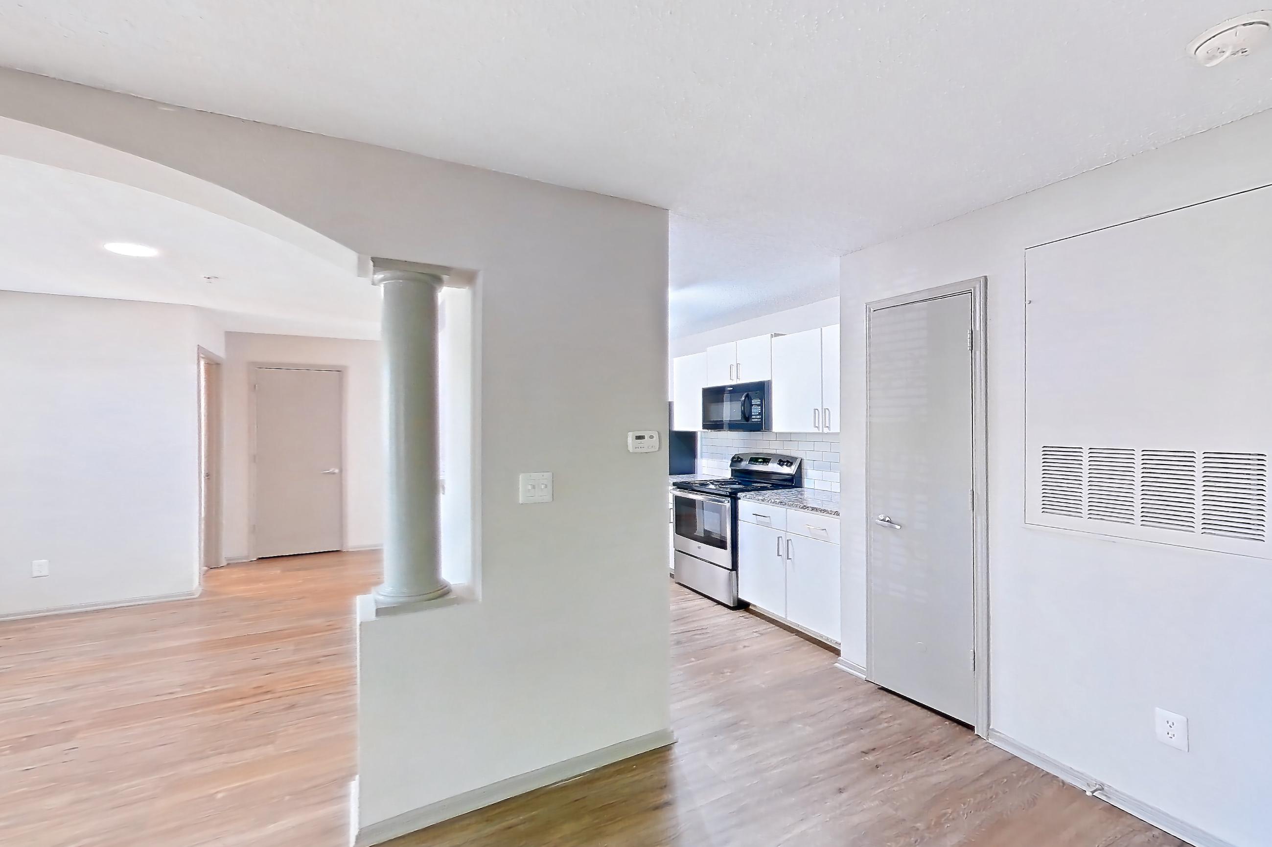 Living room with electric range, light countertops, light wood-finish flooring, oven/range, and stainless steel appliances, Apartment 62-D08 at Crosstown at Chapel Hill