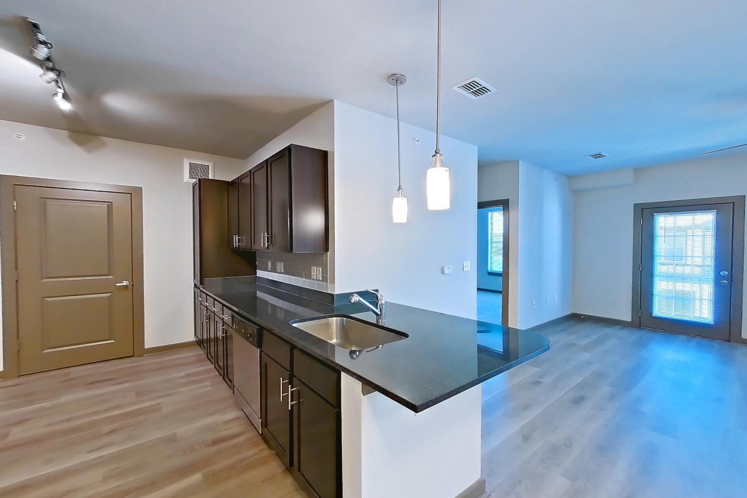 Living space with dark stone countertops, dishwasher, electric range, light wood-finish flooring, oven/range, refrigerator, and stainless steel appliances, Apartment 800-203G at Park 9