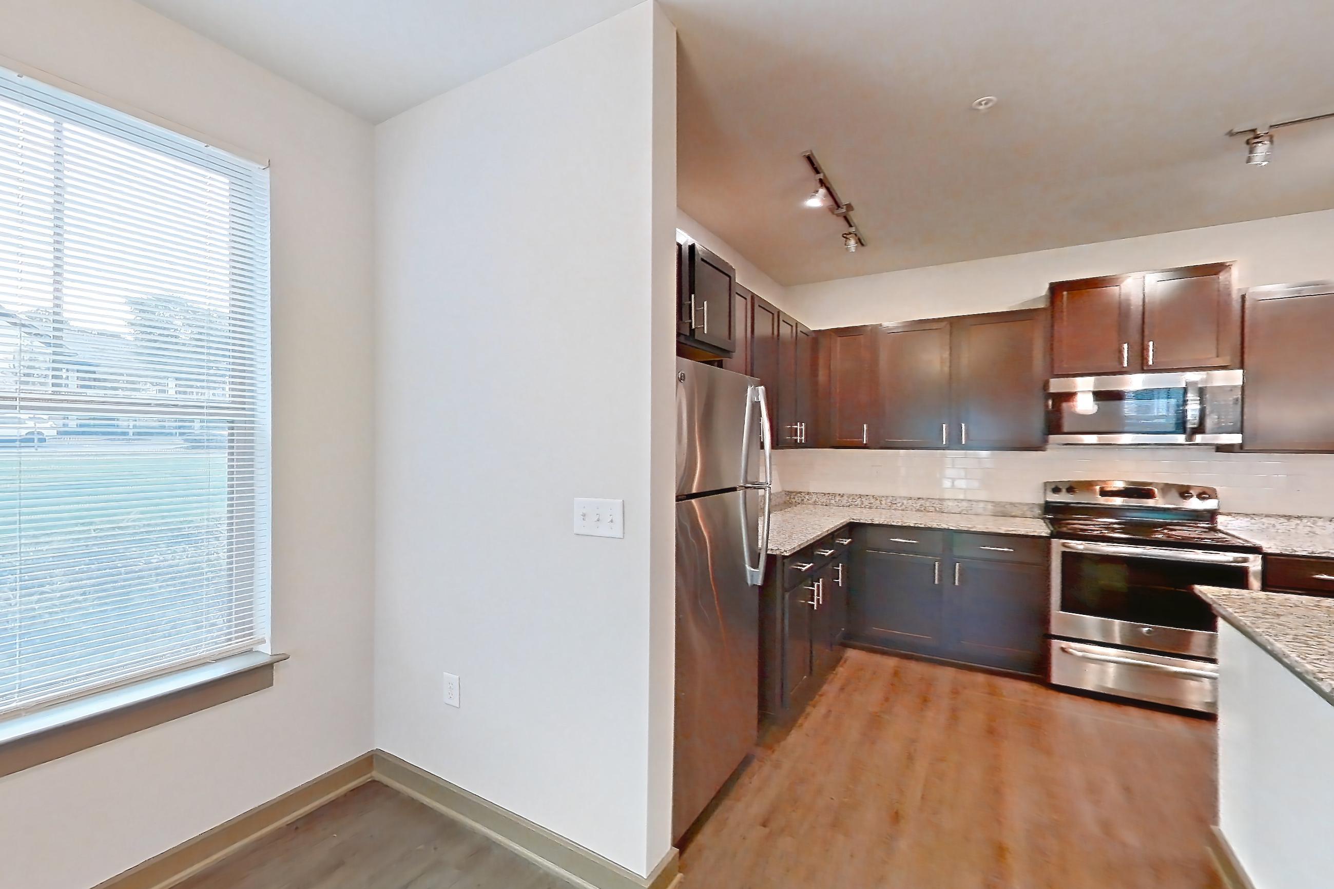 Dining room with dark wood-finish flooring, electric range, light countertops, light stone countertops, microwave, oven/range, refrigerator, and stainless steel appliances, Apartment 902-108 at Park 9