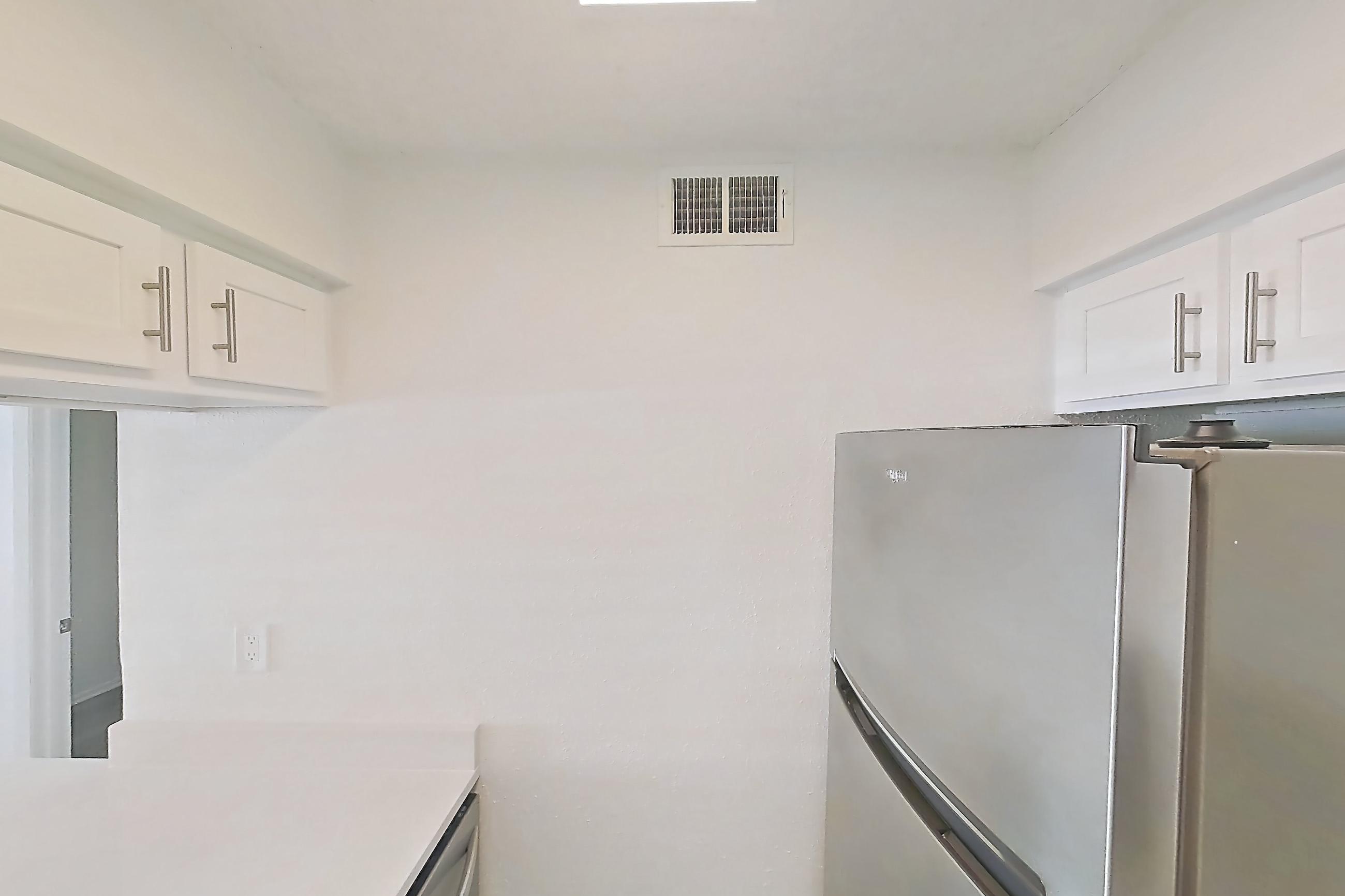 Kitchen with dishwasher, light countertops, light wood-finish flooring, microwave, oven/range, refrigerator, and stainless steel appliances, Apartment 09-106 at St. James Crossing