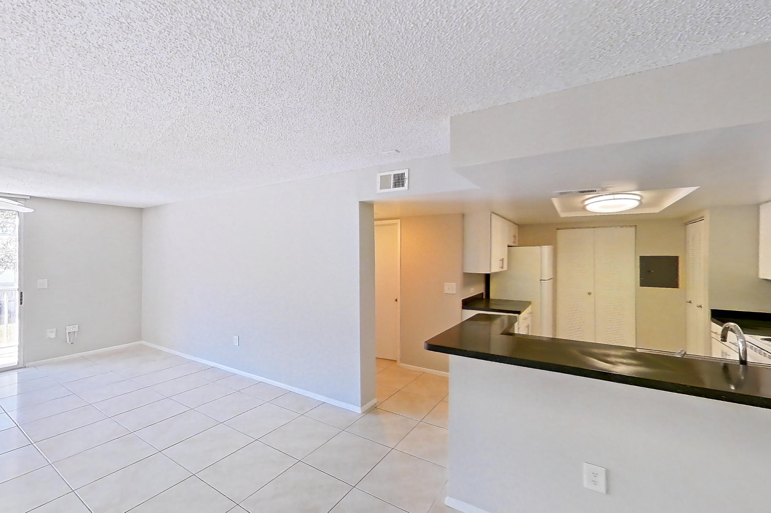 Living space with dark countertops, electric range, light tile flooring, oven/range, refrigerator, and white appliances, Apartment 01-11838 at Sabal Pointe