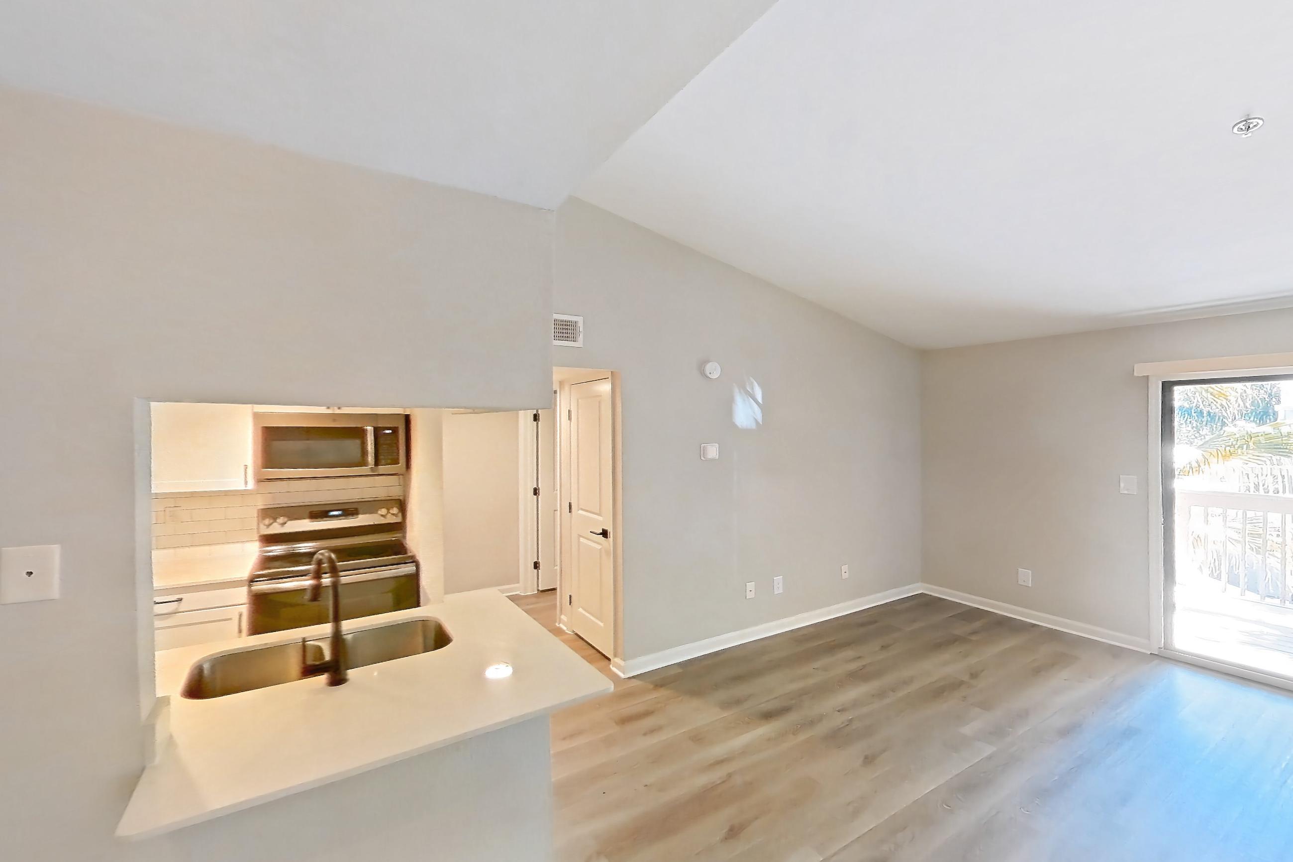 Dining room with electric range, light countertops, light wood-finish flooring, oven/range, and stainless steel appliances, Apartment 04-204 at St. James Crossing
