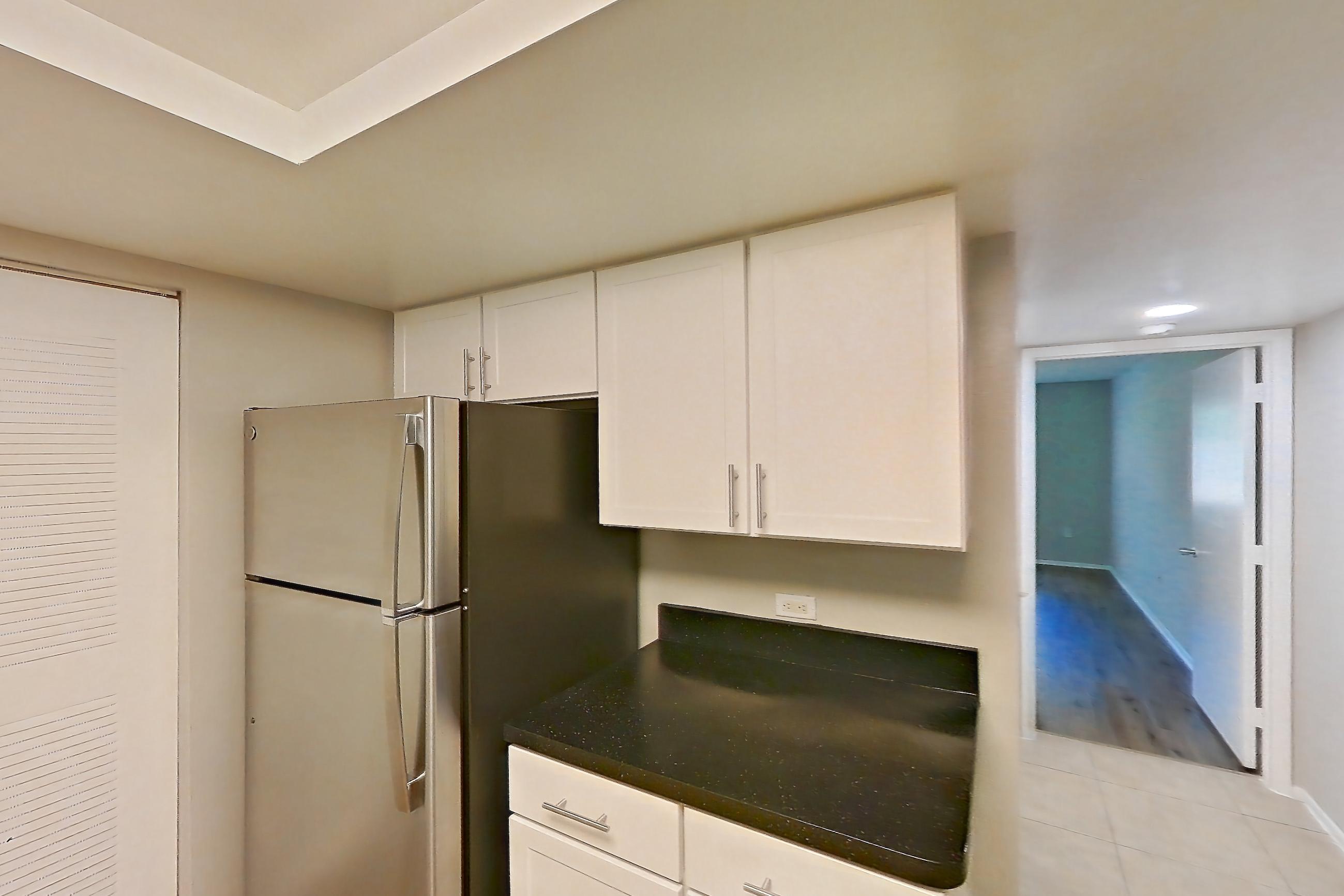 Kitchen with dark countertops, dishwasher, electric range, light tile flooring, microwave, oven/range, refrigerator, and stainless steel appliances, Apartment 03-11932 at Sabal Pointe