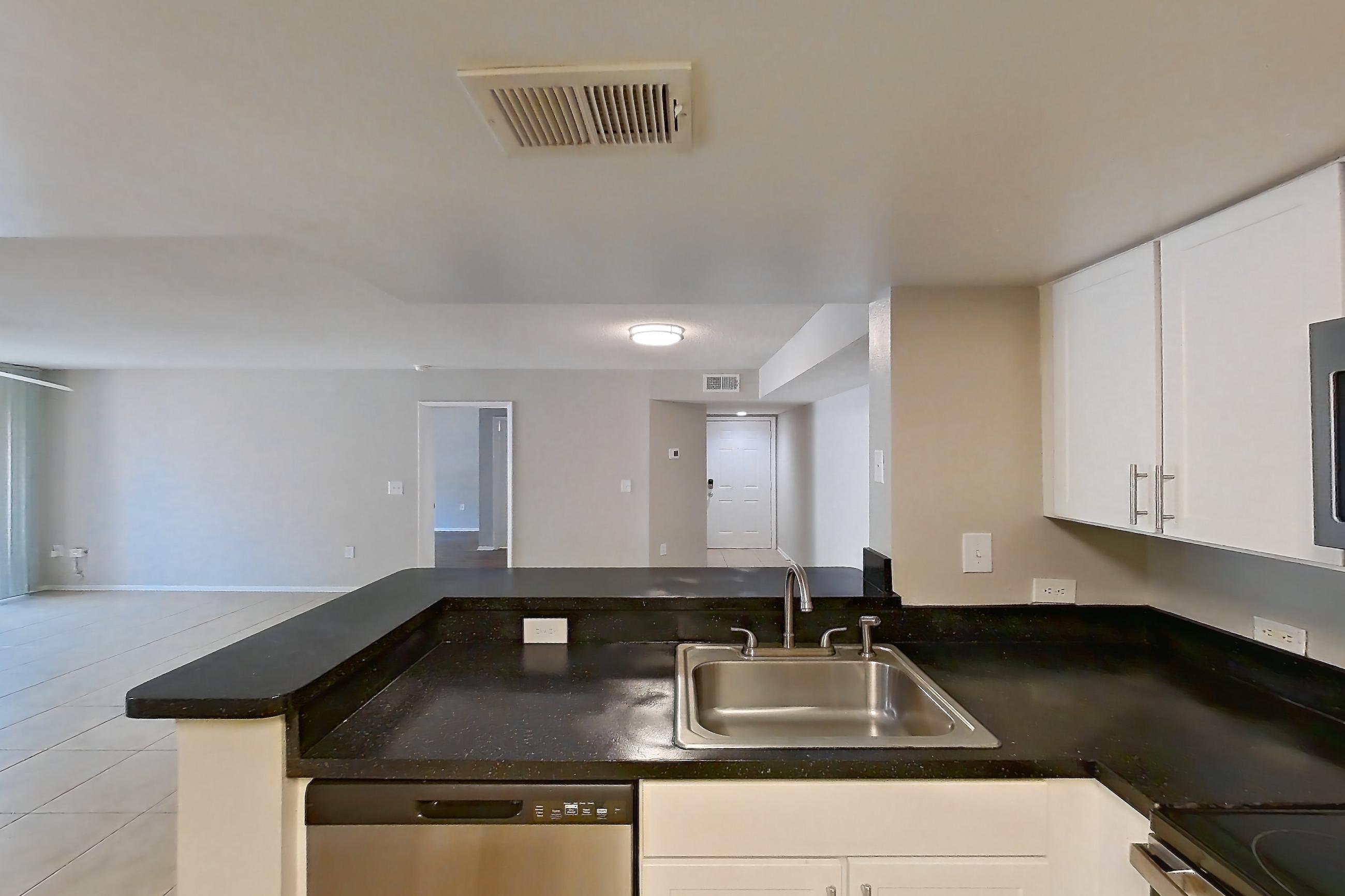 Kitchen with dark countertops, dishwasher, electric range, light tile flooring, microwave, oven/range, refrigerator, and stainless steel appliances, Apartment 03-11932 at Sabal Pointe