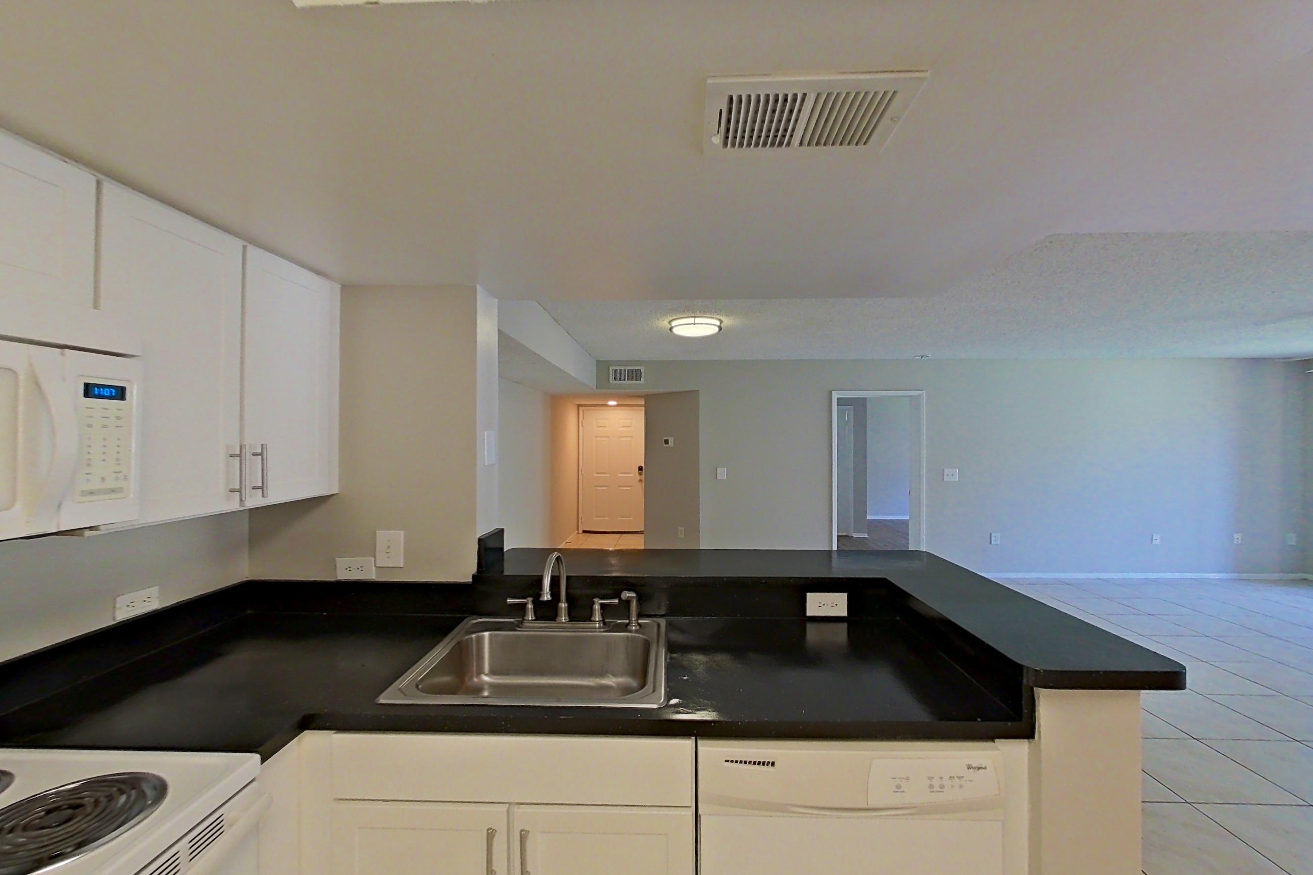 Kitchen with dark countertops, dishwasher, electric range, light tile flooring, microwave, oven/range, and white appliances, Apartment 03-11934 at Sabal Pointe