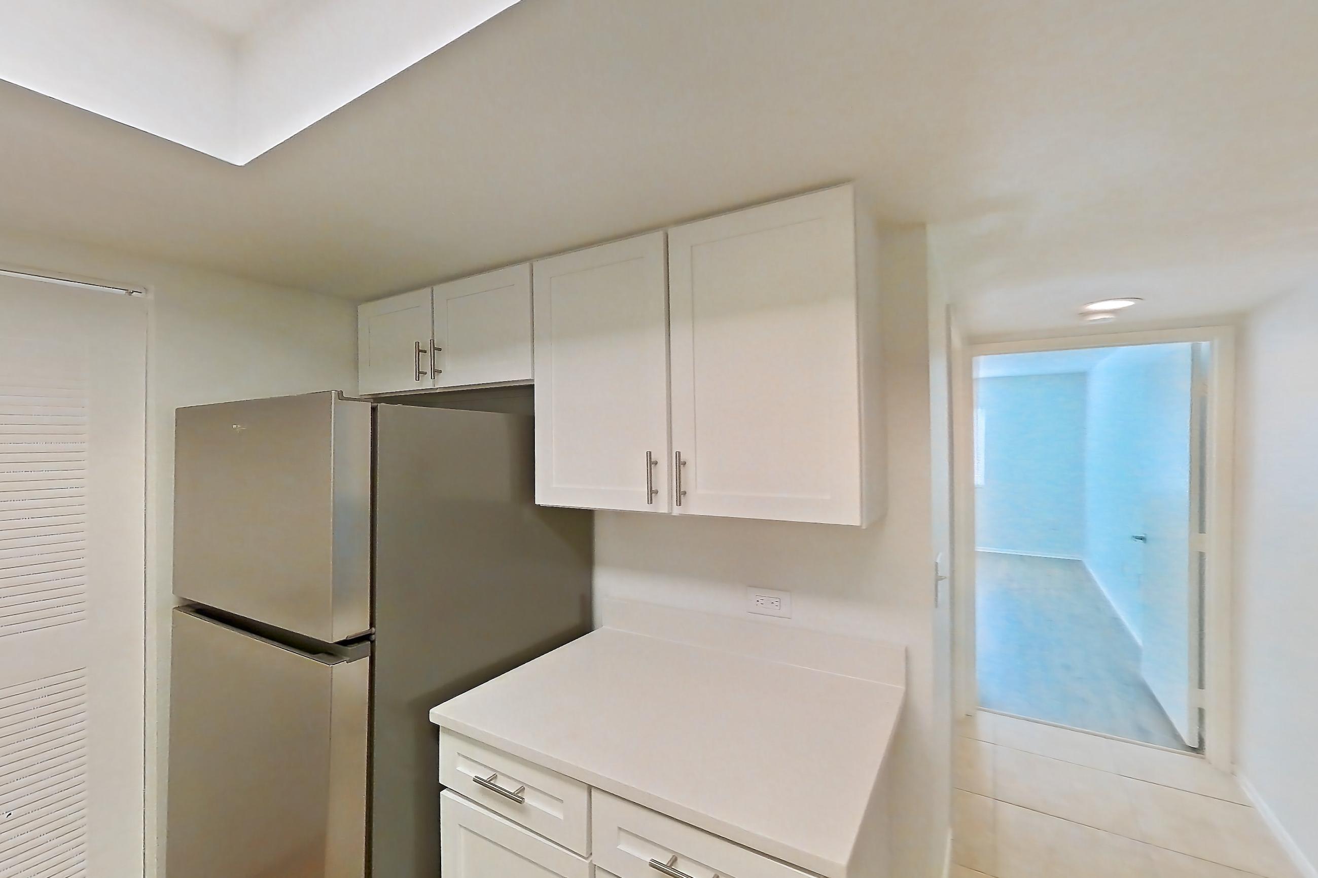 Kitchen with dishwasher, electric range, light countertops, light stone countertops, light tile flooring, microwave, oven/range, refrigerator, and stainless steel appliances, Apartment 06-12074 at Sabal Pointe