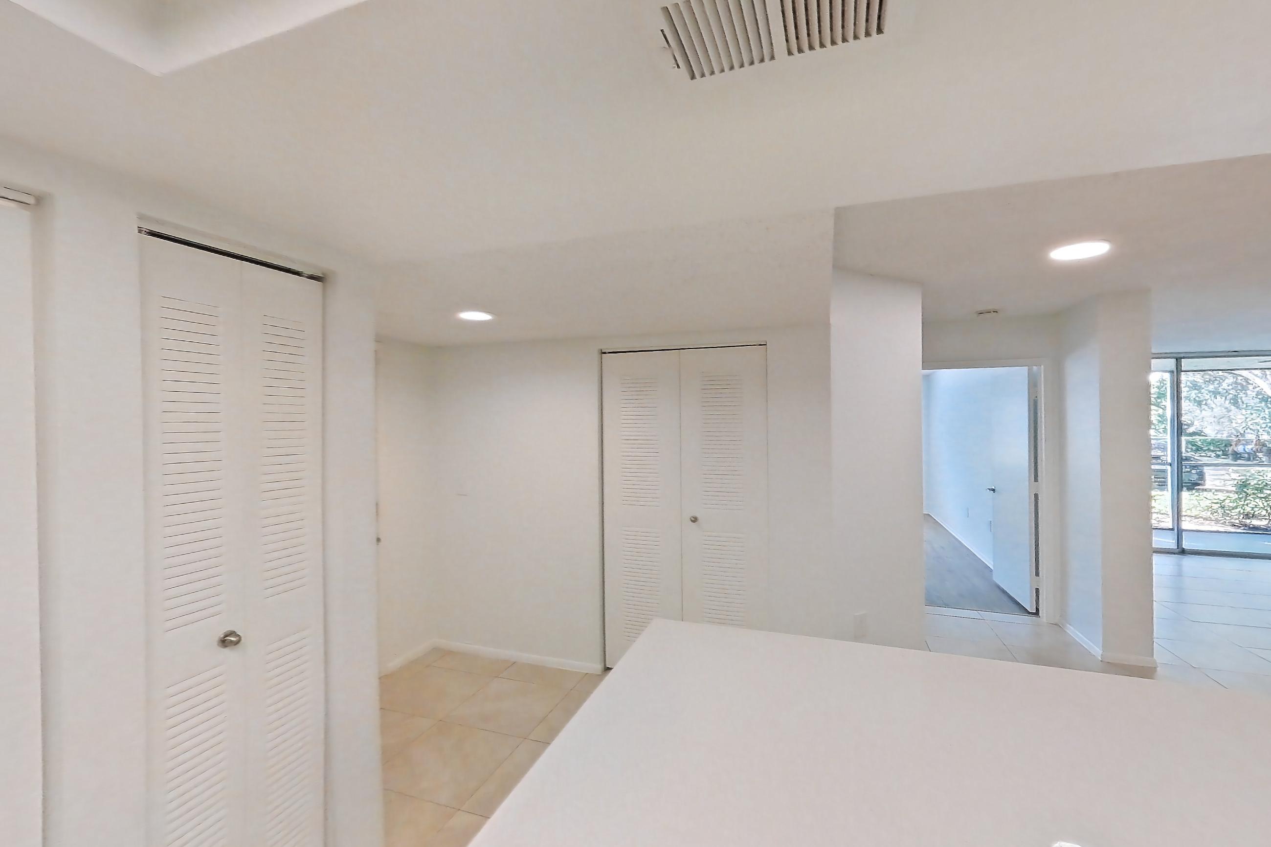 Kitchen with dishwasher, electric range, light countertops, light stone countertops, light tile flooring, microwave, oven/range, and stainless steel appliances, Apartment 09-12244 at Sabal Pointe