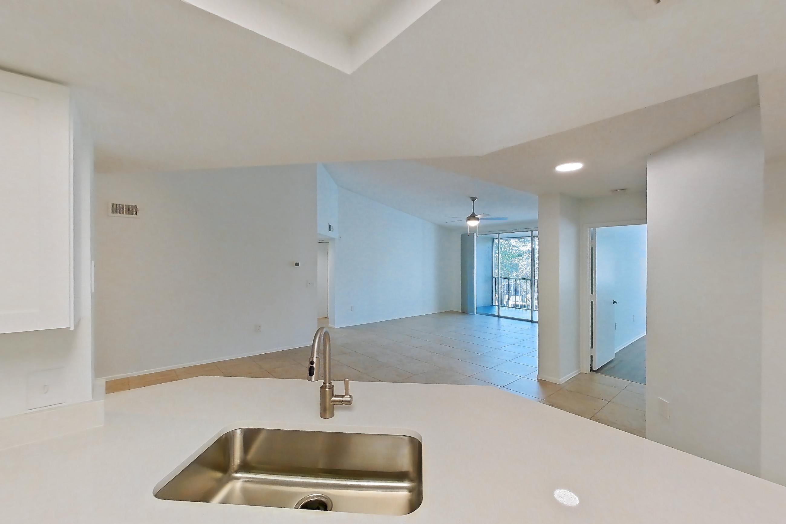 Kitchen with dishwasher, electric range, light countertops, light stone countertops, light tile flooring, microwave, oven/range, and stainless steel appliances, Apartment 09-12234 at Sabal Pointe