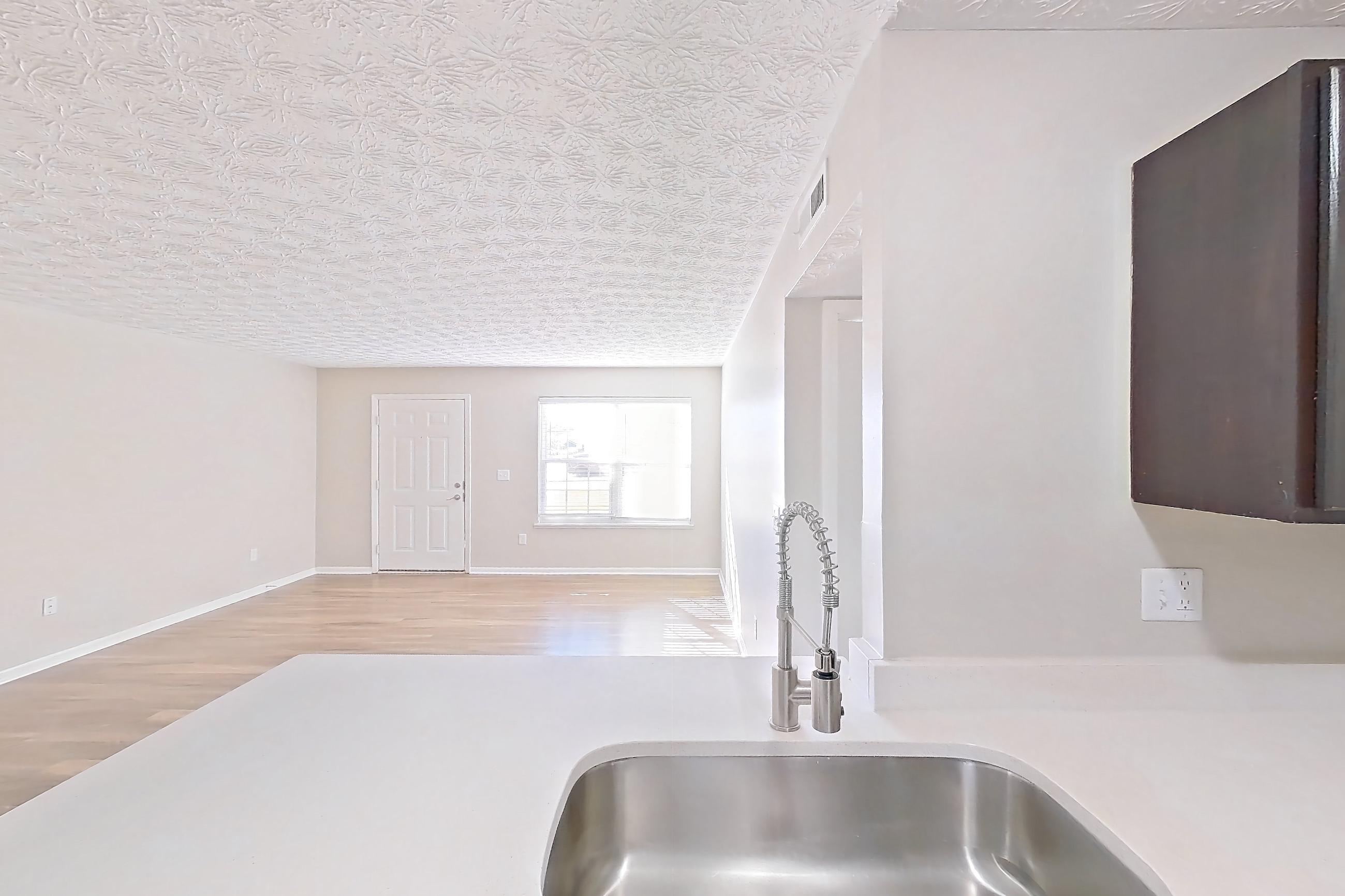 Kitchen with black appliances, dishwasher, electric range, light countertops, light stone countertops, light wood-finish flooring, microwave, oven/range, and refrigerator, Apartment 3152BLD at The Gardens Columbus