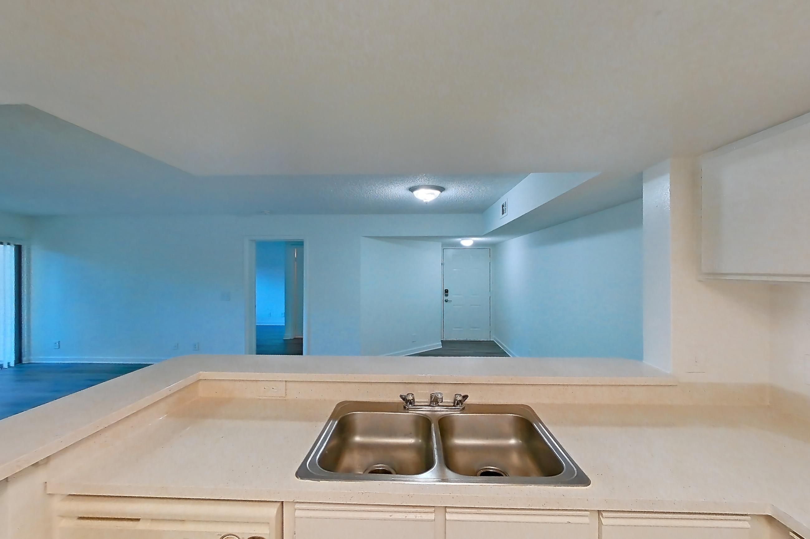 Kitchen with dark wood-finish flooring, dishwasher, electric range, light countertops, light wood-finish flooring, oven/range, refrigerator, and white appliances, Apartment 03-015 at The Reserve at Ashley Lake