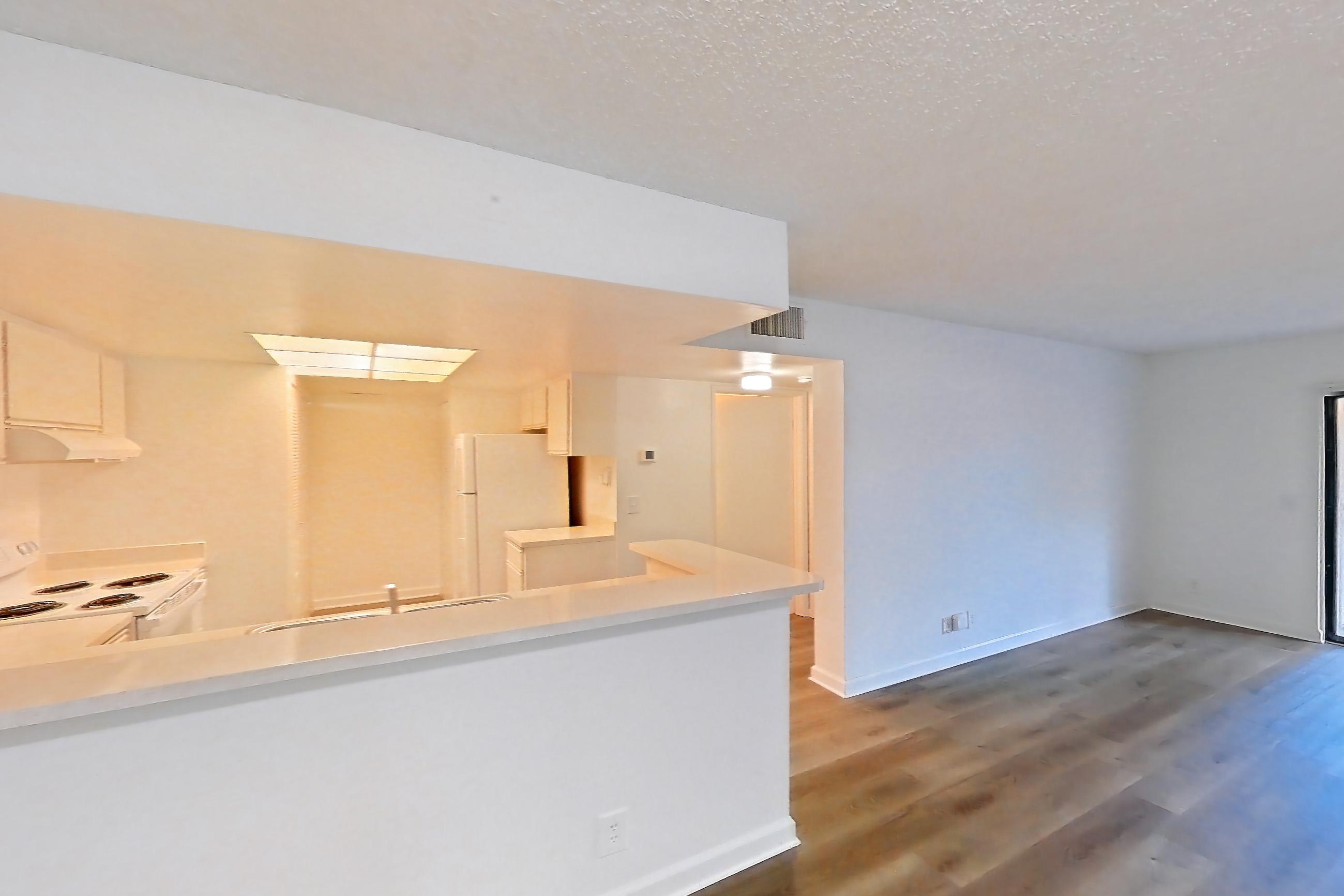Living space with dark wood-finish flooring, electric range, light wood-finish flooring, oven/range, refrigerator, and white appliances, Apartment 03-015 at The Reserve at Ashley Lake