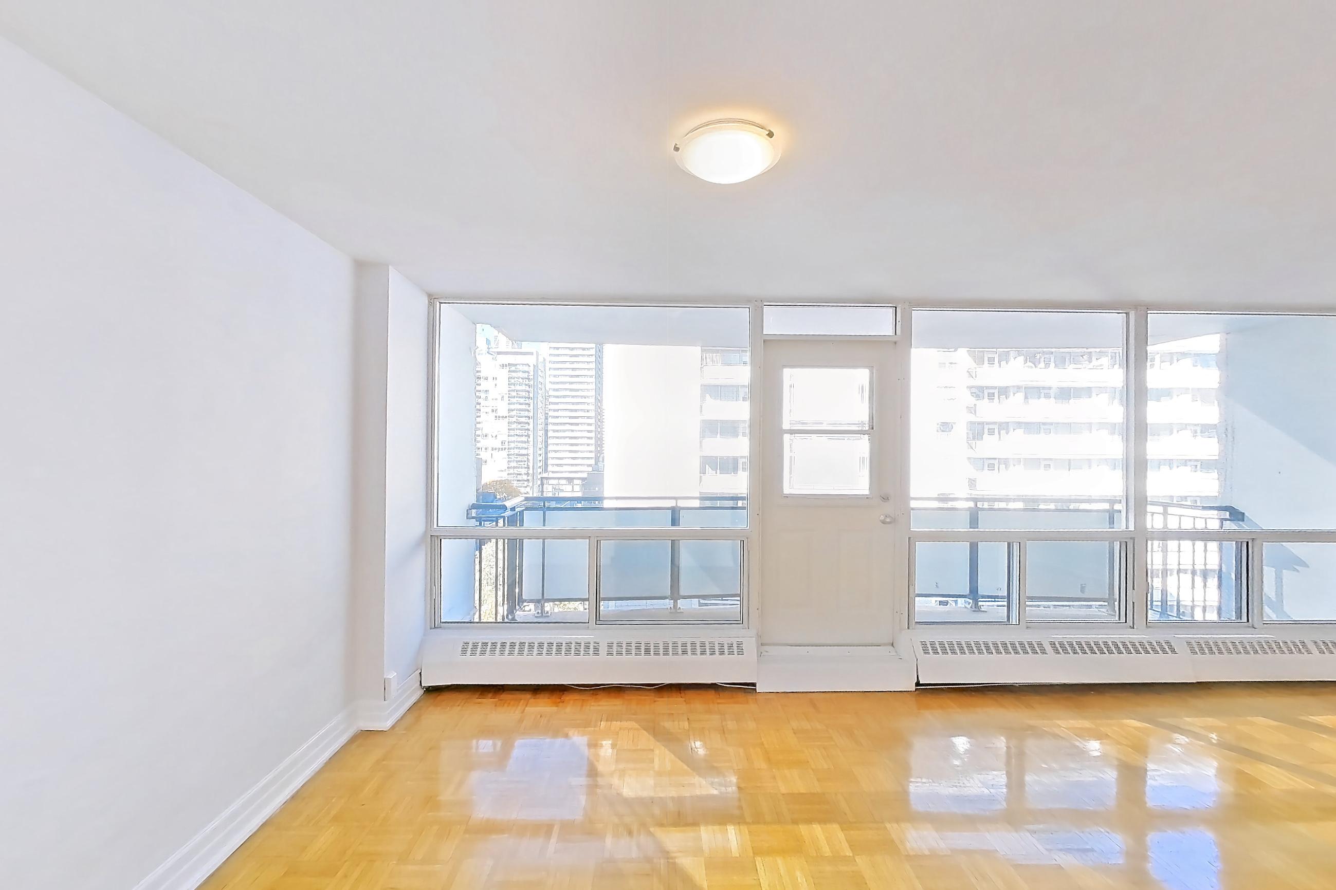 Kitchen with baseboard heating, dark countertops, dishwasher, electric range, light tile flooring, light wood-finish flooring, oven/range, parquet flooring, refrigerator, and white appliances, Apartment 1-1204 at Village Green