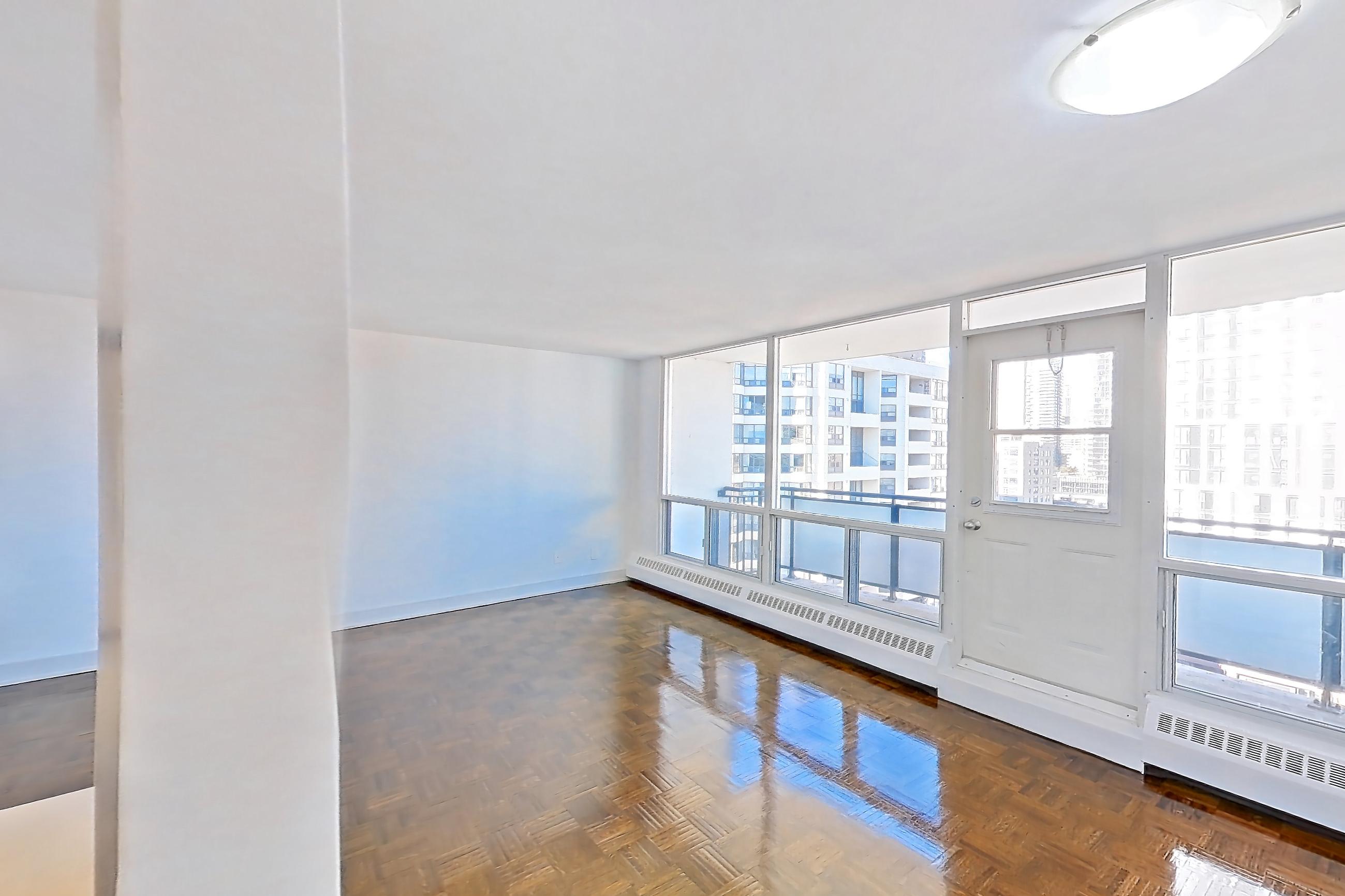 Kitchen with baseboard heating, dark wood-finish flooring, electric range, light countertops, light stone countertops, light tile flooring, oven/range, parquet flooring, refrigerator, and stainless steel appliances, Apartment 1-1611 at Village Green