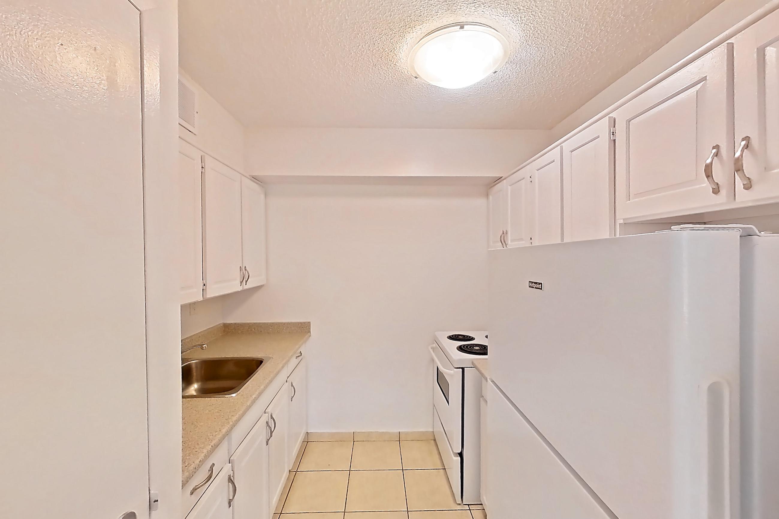 Kitchen with electric range, light countertops, light tile flooring, oven/range, refrigerator, and white appliances, Apartment 0107 at 77 Davisville