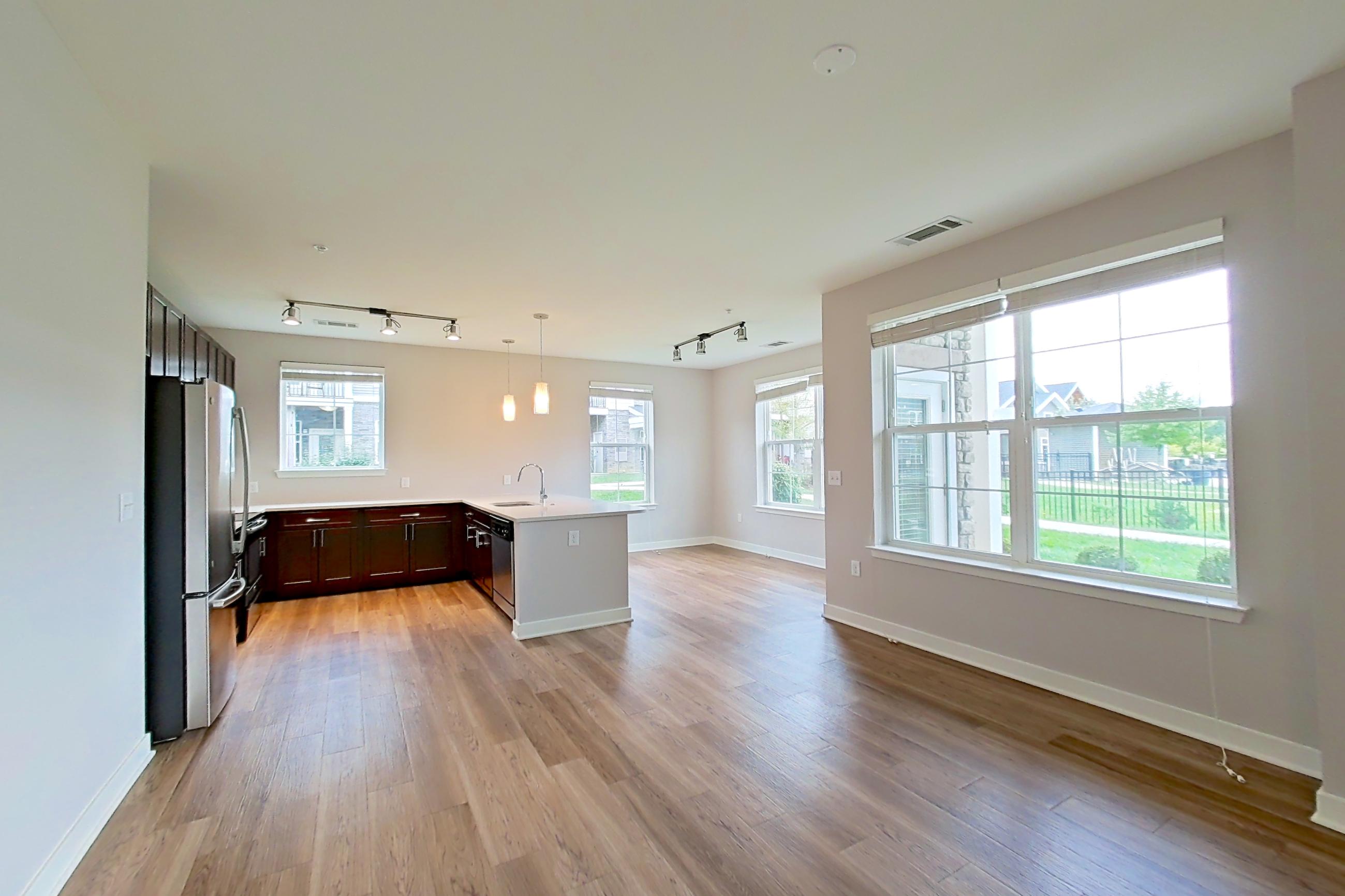 Living space with dishwasher, light countertops, light wood-finish flooring, refrigerator, and stainless steel appliances, Apartment 10102 at Briggs & Union