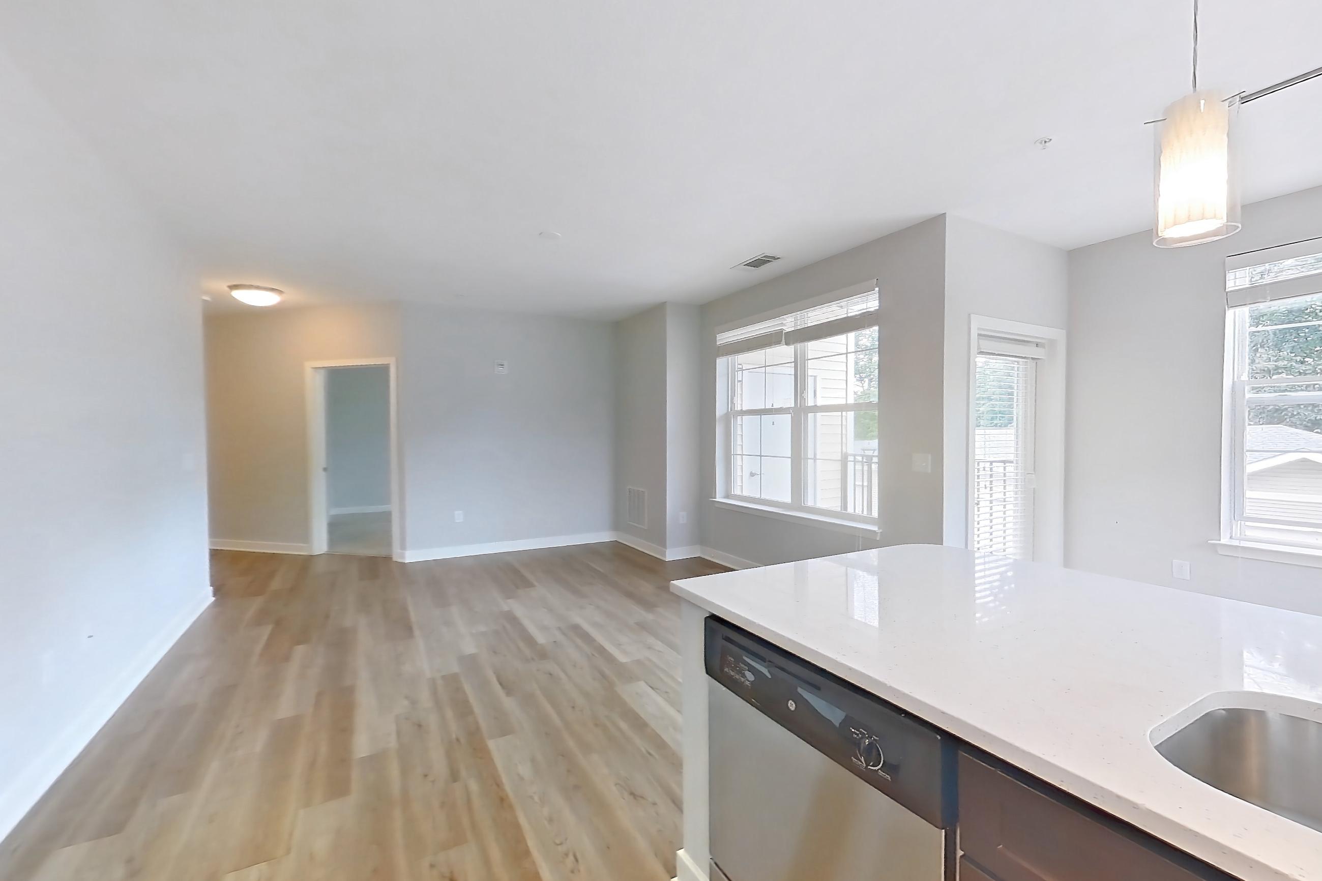 Kitchen with dishwasher, electric range, light countertops, light stone countertops, light wood-finish flooring, microwave, oven/range, refrigerator, and stainless steel appliances, Apartment 10201 at Briggs & Union