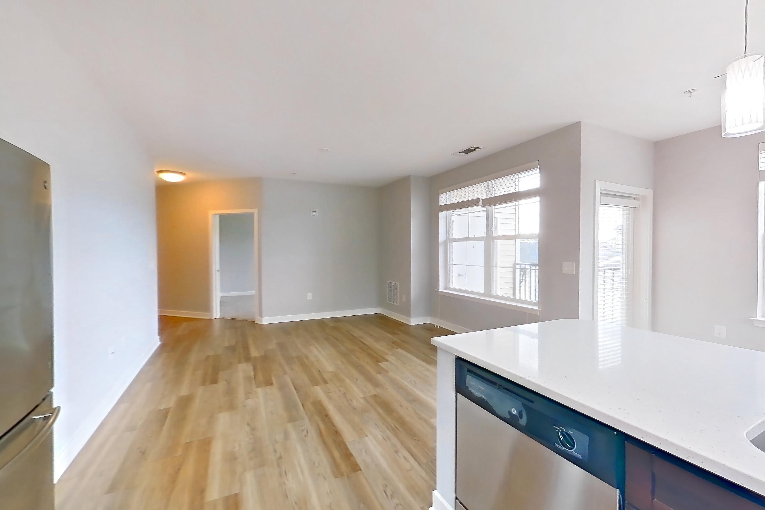 Kitchen with dishwasher, electric range, light countertops, light stone countertops, light wood-finish flooring, microwave, oven/range, refrigerator, and stainless steel appliances, Apartment 13201 at Briggs & Union