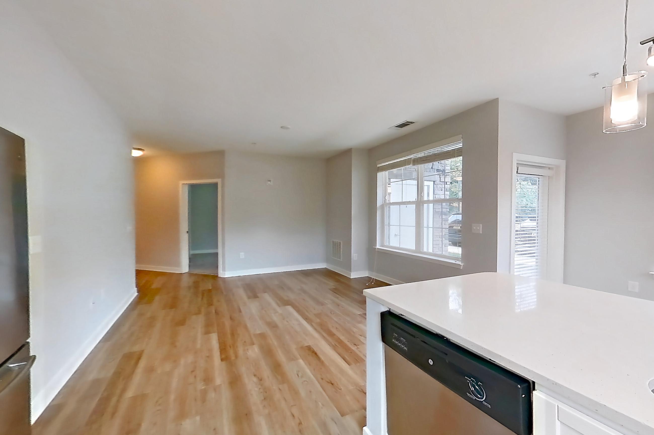 Kitchen with dishwasher, electric range, light countertops, light stone countertops, light wood-finish flooring, microwave, oven/range, refrigerator, and stainless steel appliances, Apartment 14101 at Briggs & Union