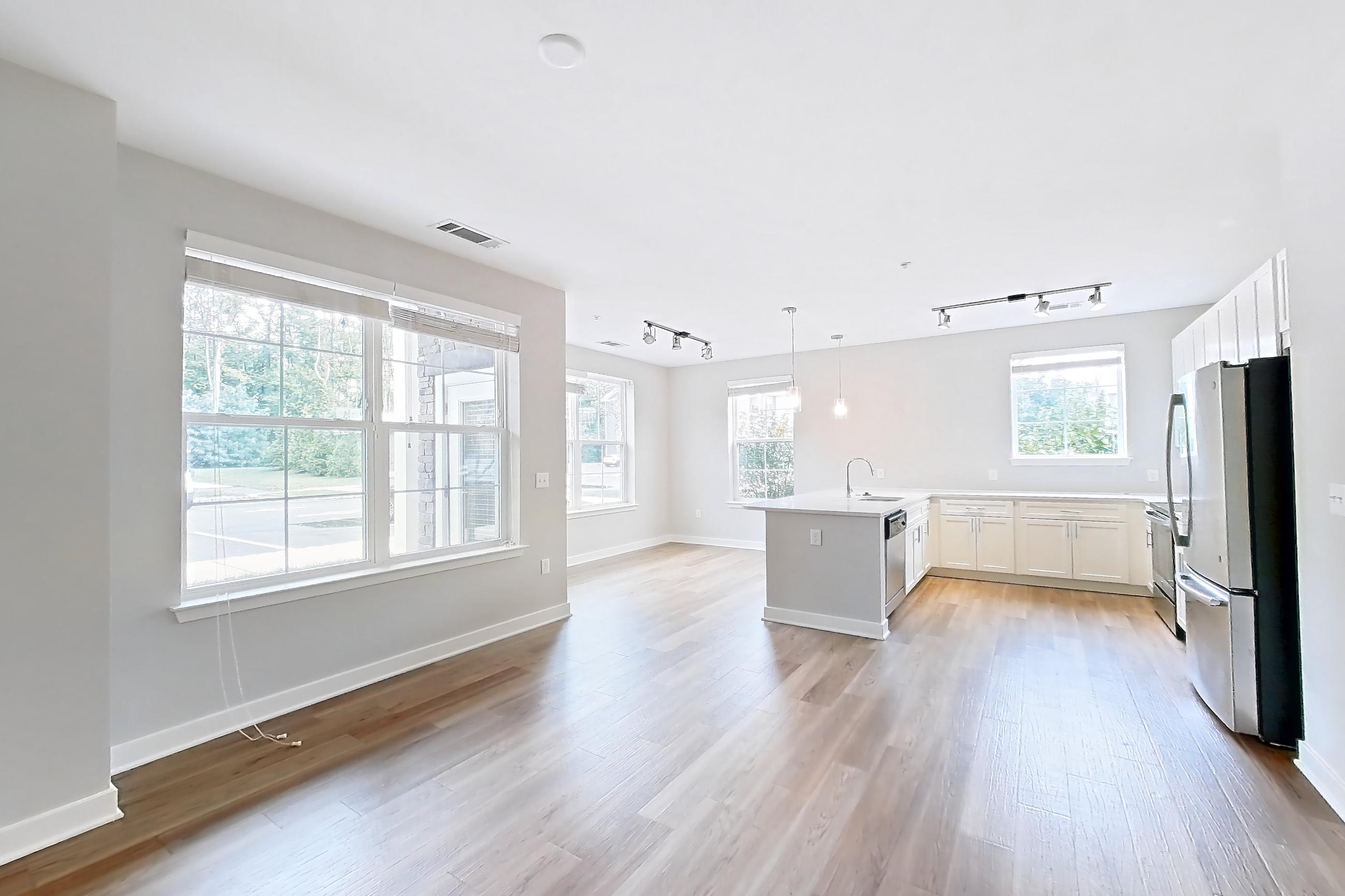 Living space with dishwasher, light countertops, light wood-finish flooring, oven/range, and stainless steel appliances, Apartment 14101 at Briggs & Union