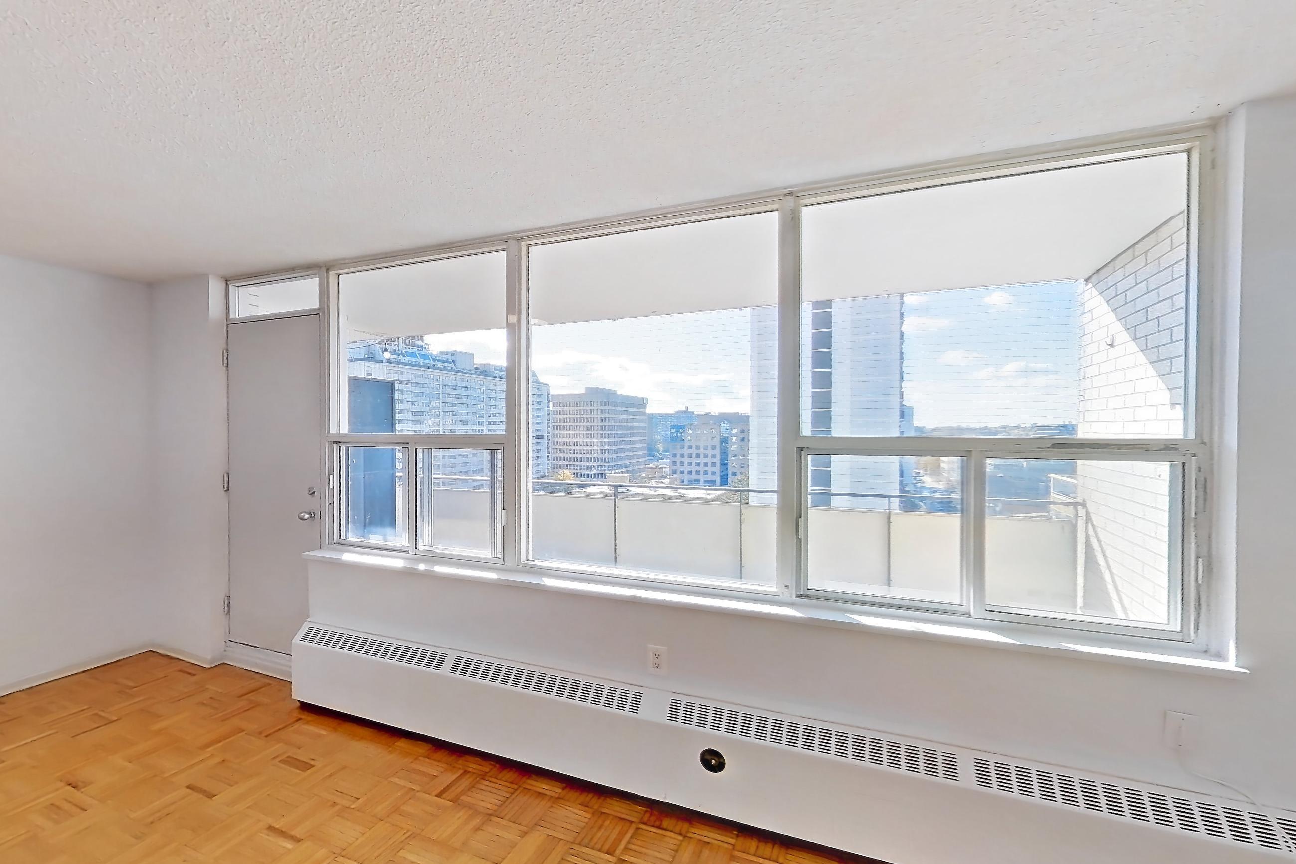 Living room with baseboard heating, light wood-finish flooring, and parquet flooring, Apartment 1018 at 77 Davisville