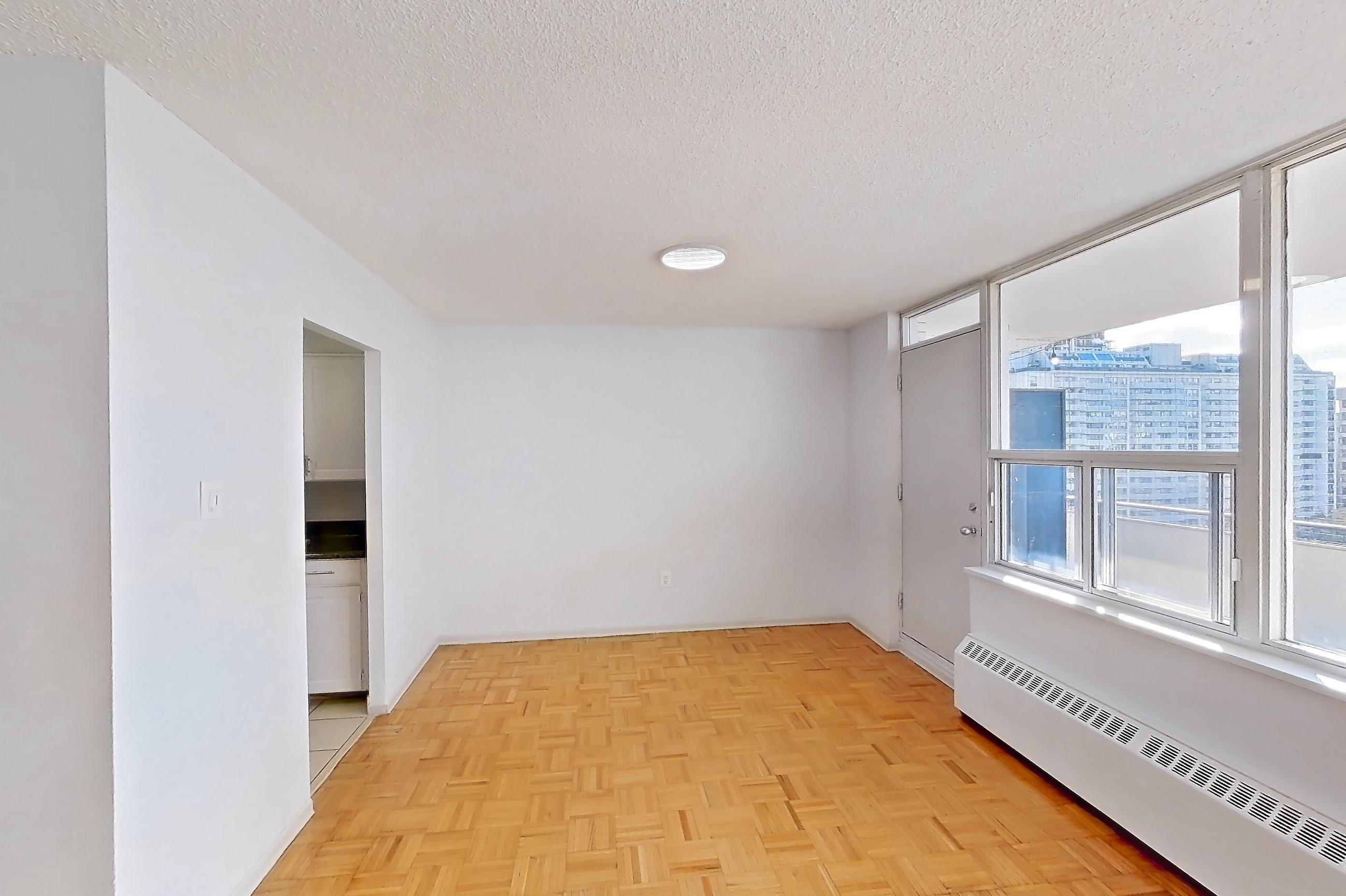Living room with baseboard heating, light wood-finish flooring, and parquet flooring, Apartment 1018 at 77 Davisville