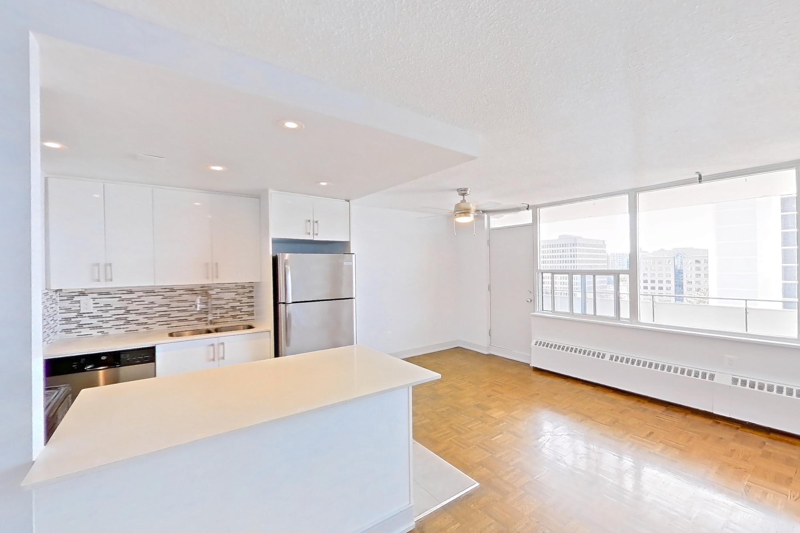 Living room with baseboard heating, dishwasher, light wood-finish flooring, parquet flooring, refrigerator, and stainless steel appliances, Apartment 0918 at 77 Davisville