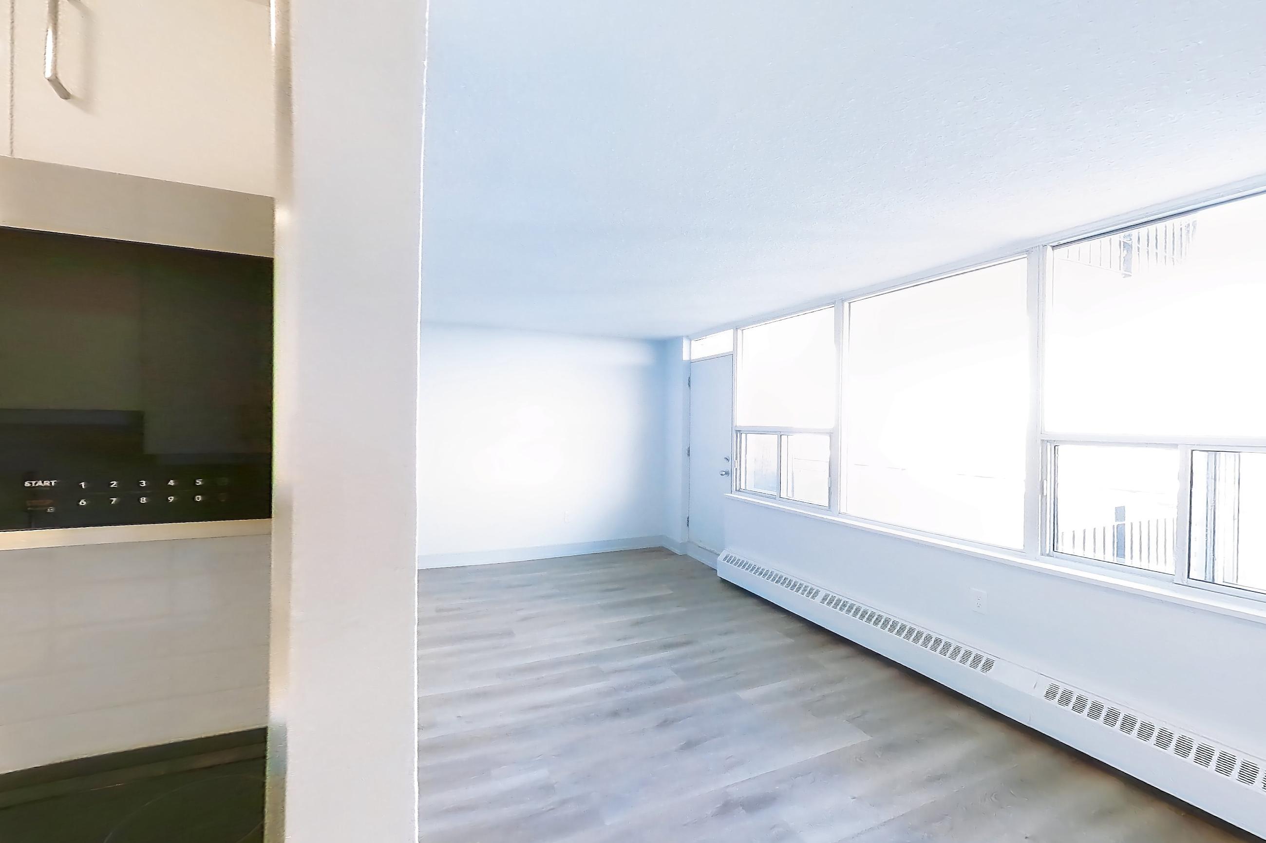 Kitchen with baseboard heating, dishwasher, electric range, light countertops, light stone countertops, light wood-finish flooring, oven/range, refrigerator, and stainless steel appliances, Apartment 2805 at 77 Davisville