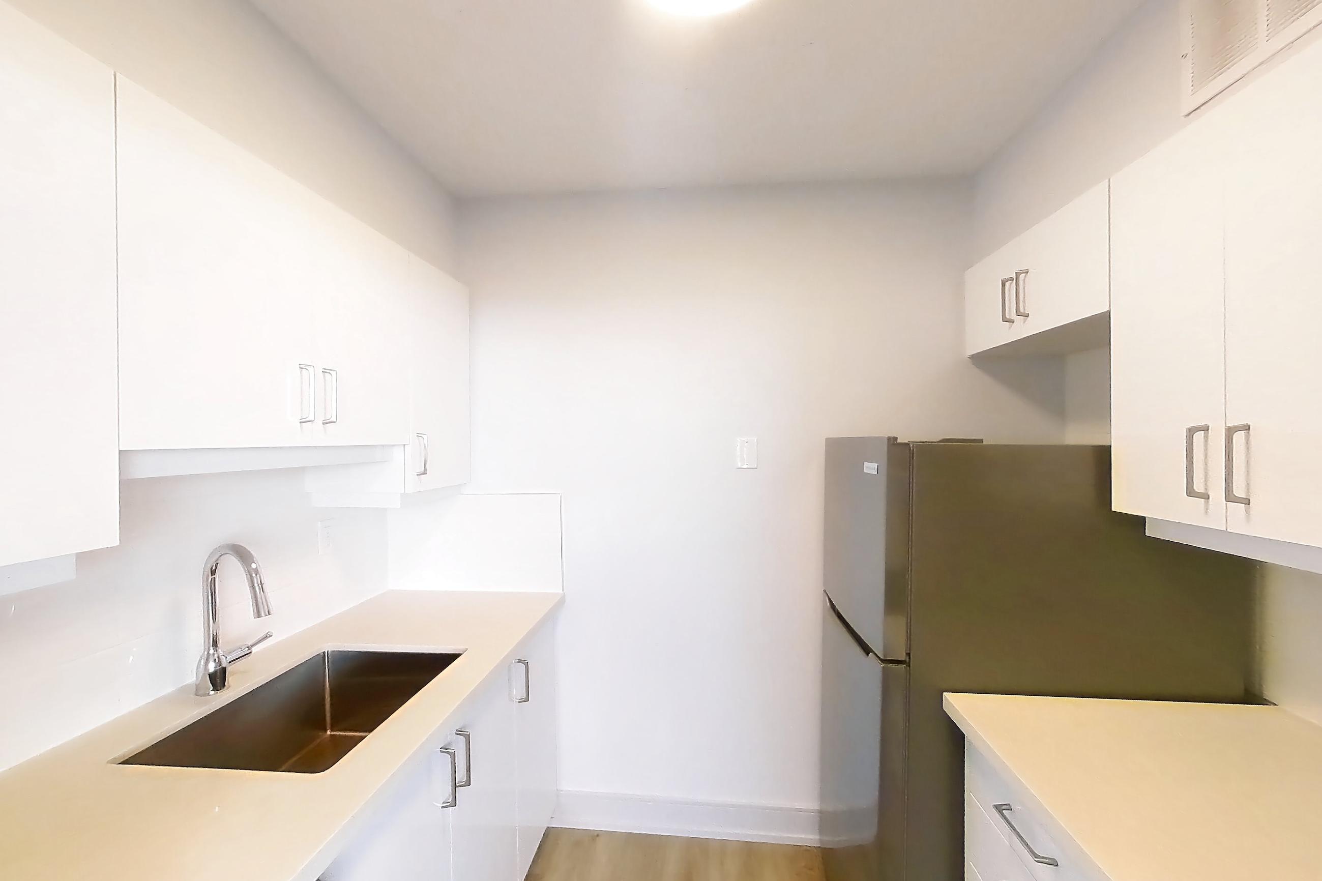 Kitchen with baseboard heating, dishwasher, electric range, light countertops, light stone countertops, light wood-finish flooring, oven/range, refrigerator, and stainless steel appliances, Apartment 2805 at 77 Davisville