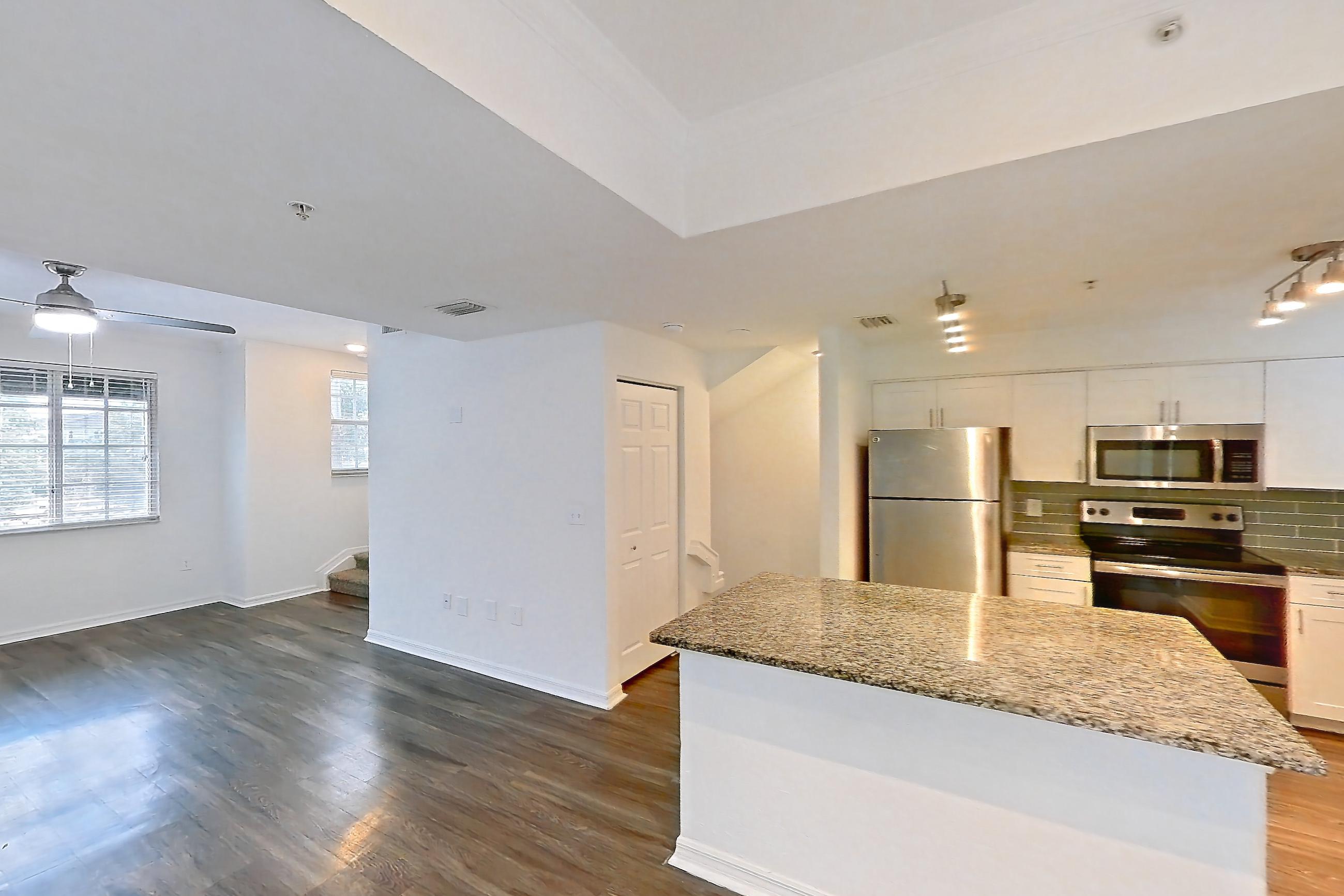 Living space with dark wood-finish flooring, dishwasher, electric range, oven/range, refrigerator, and stainless steel appliances, Apartment 16-02573 at Solano at Miramar