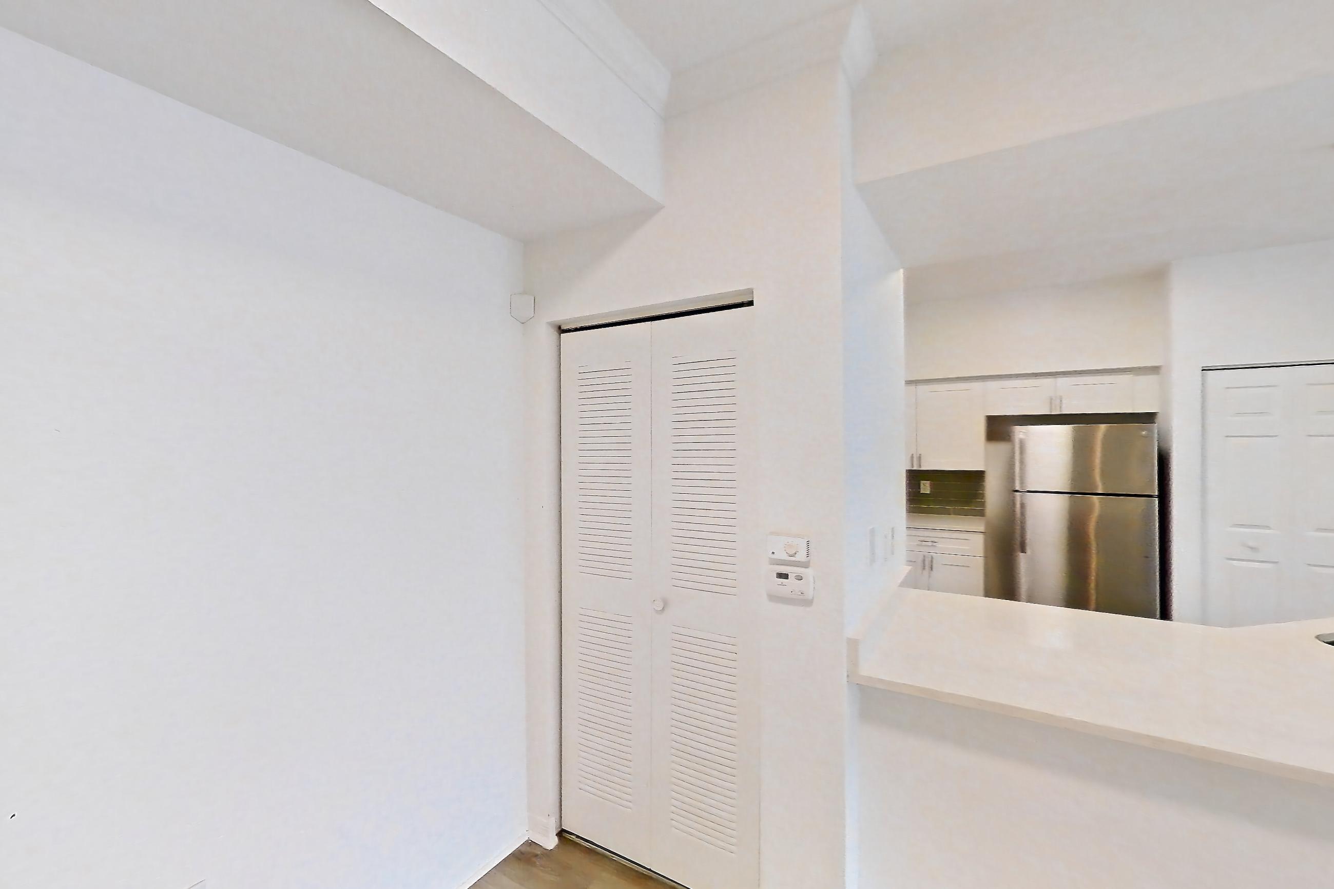 Living space with light countertops, light wood-finish flooring, refrigerator, and stainless steel appliances, Apartment 03-304 at Solano at Miramar