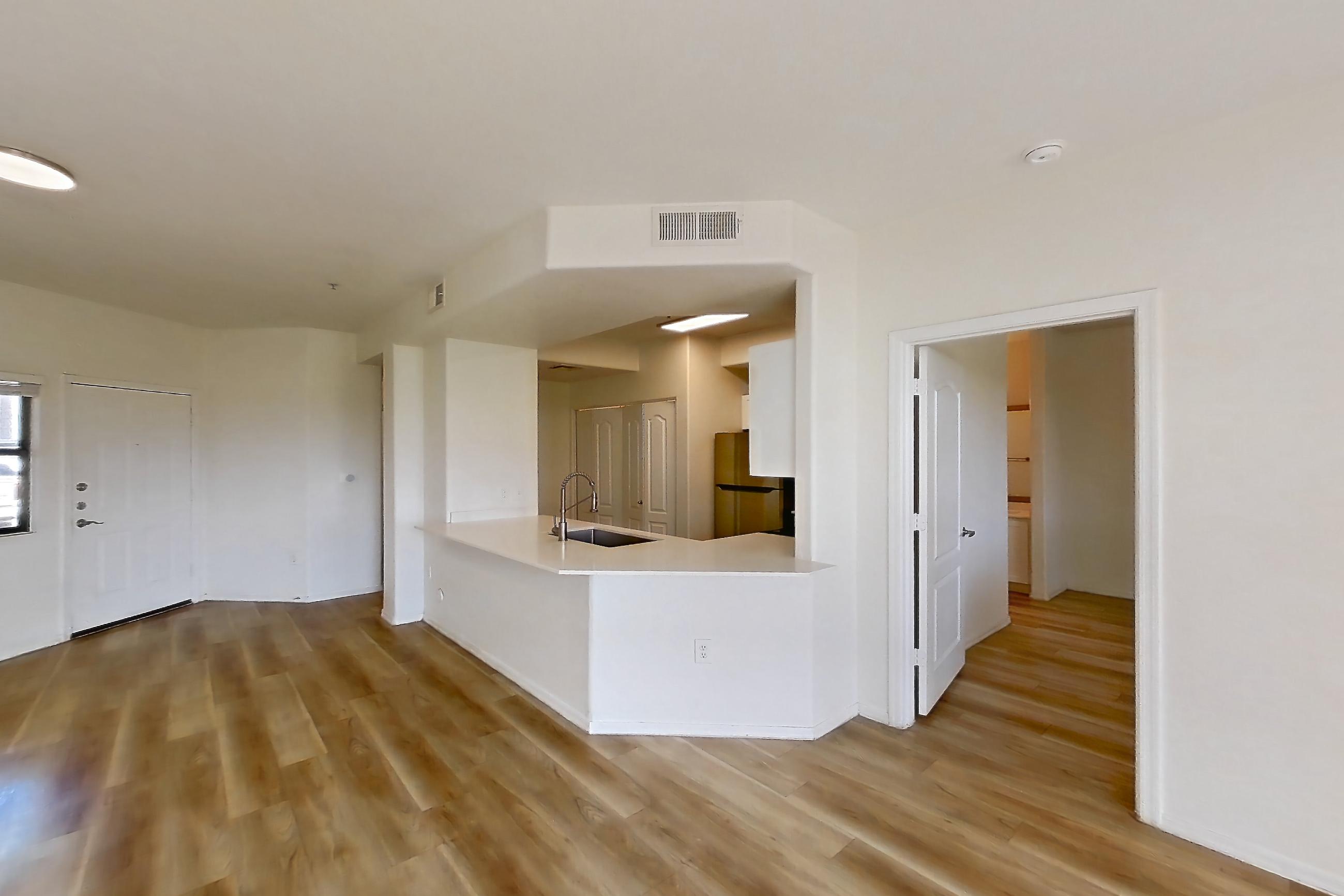 Living room with light wood-finish flooring, refrigerator, and stainless steel appliances, Apartment 1114 at Dobson 2222
