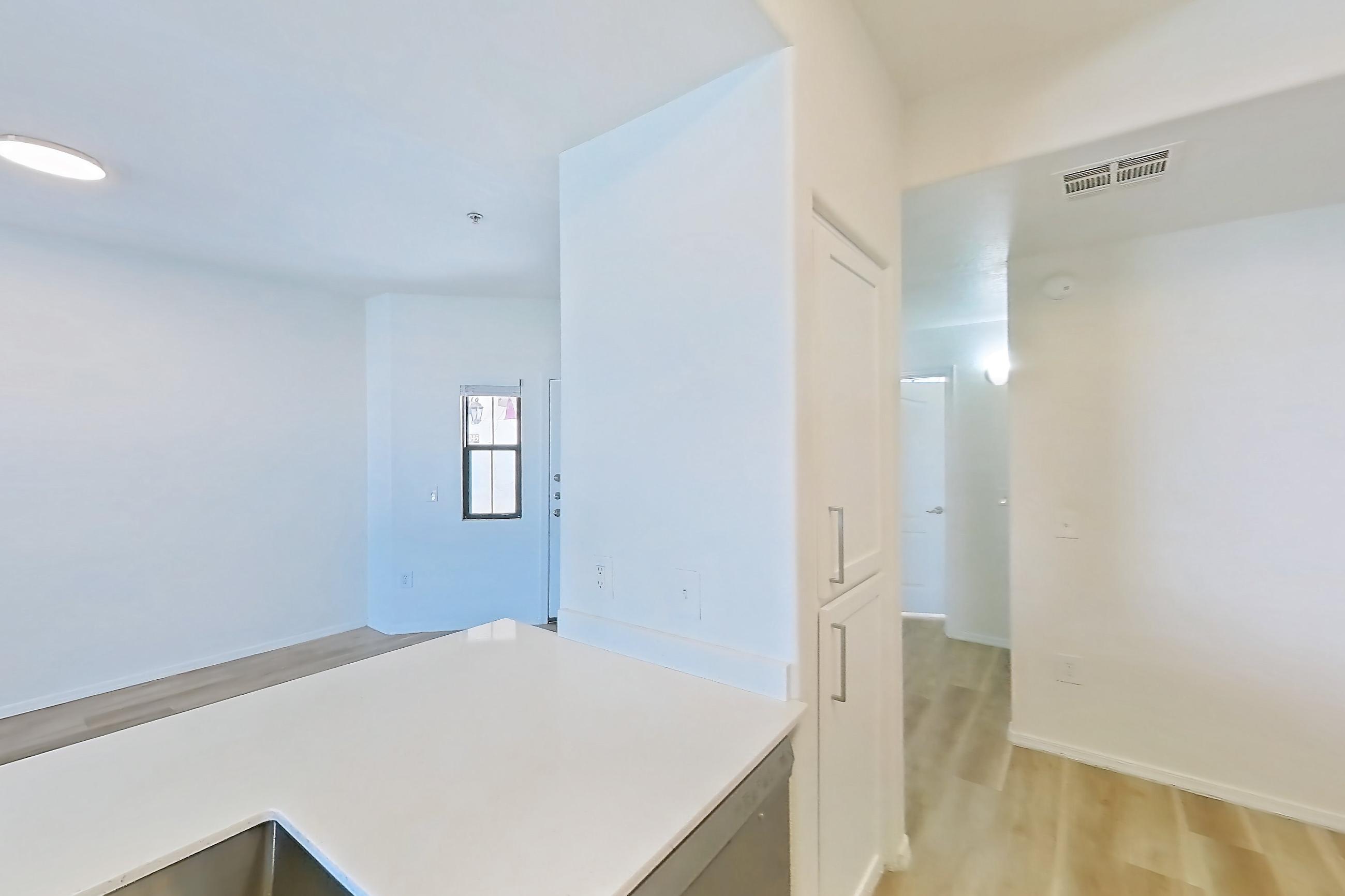Kitchen with dishwasher, electric range, light stone countertops, light wood-finish flooring, microwave, oven/range, and stainless steel appliances, Apartment 2046 at Dobson 2222
