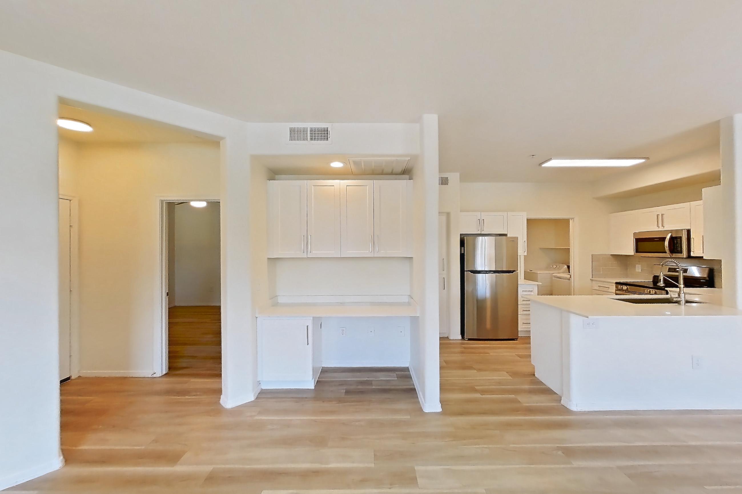 Living room with electric range, light countertops, light wood-finish flooring, oven/range, refrigerator, and stainless steel appliances, Apartment 1033 at Dobson 2222