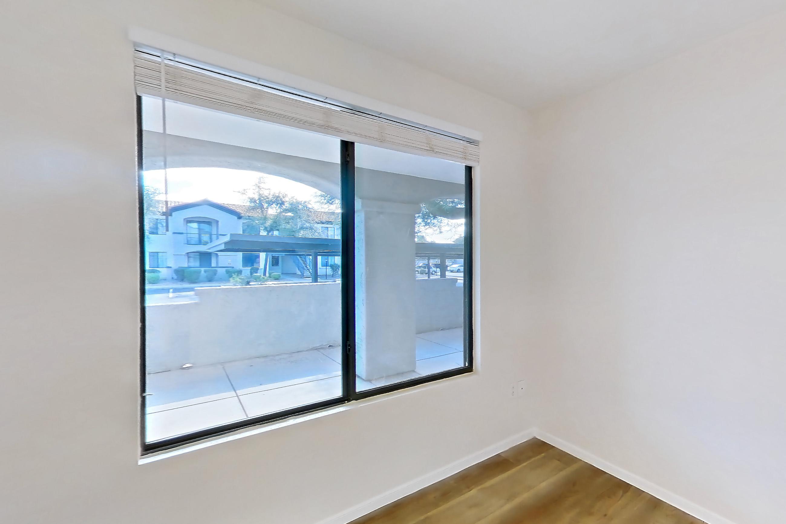 Living room with light wood-finish flooring, microwave, refrigerator, and stainless steel appliances, Apartment 1087 at Dobson 2222