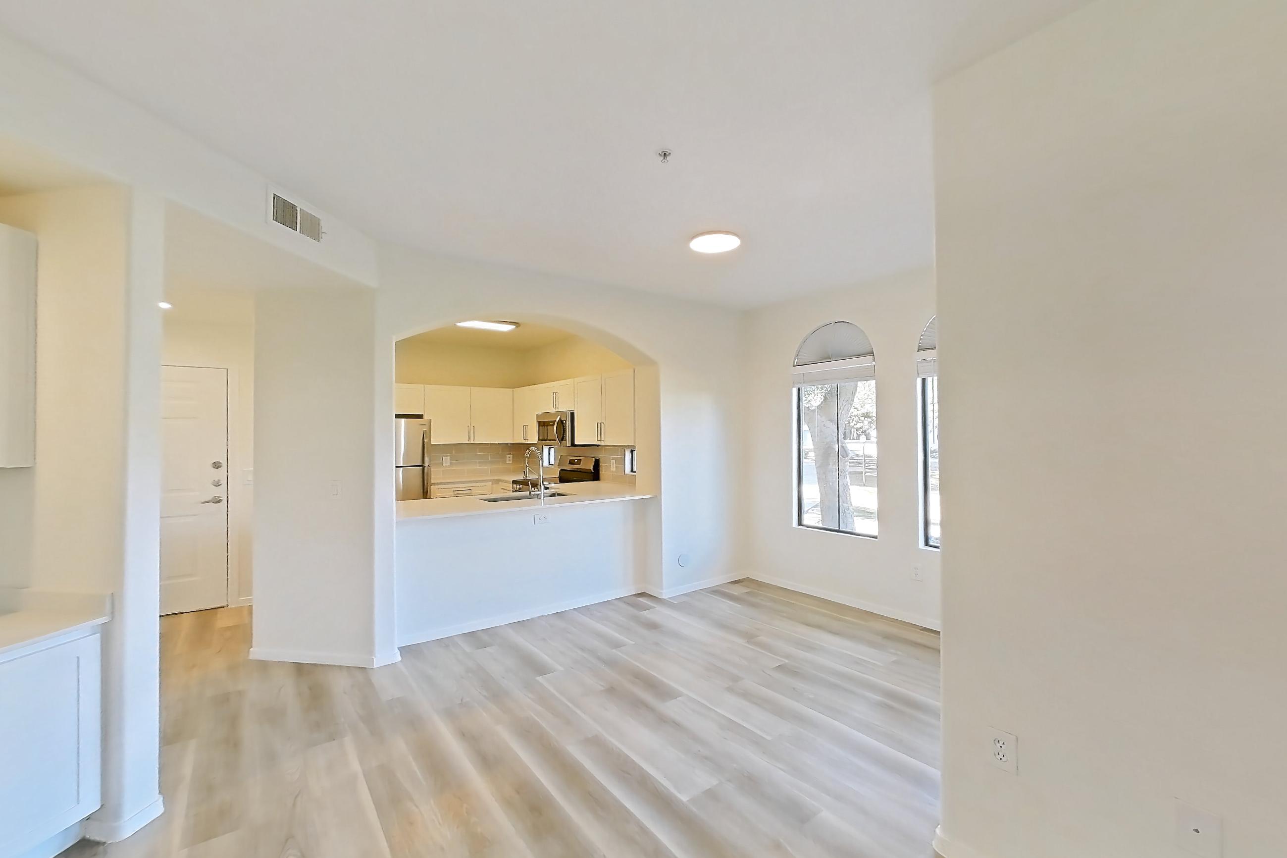 Living room with light wood-finish flooring, oven/range, refrigerator, and stainless steel appliances, Apartment 1091 at Dobson 2222