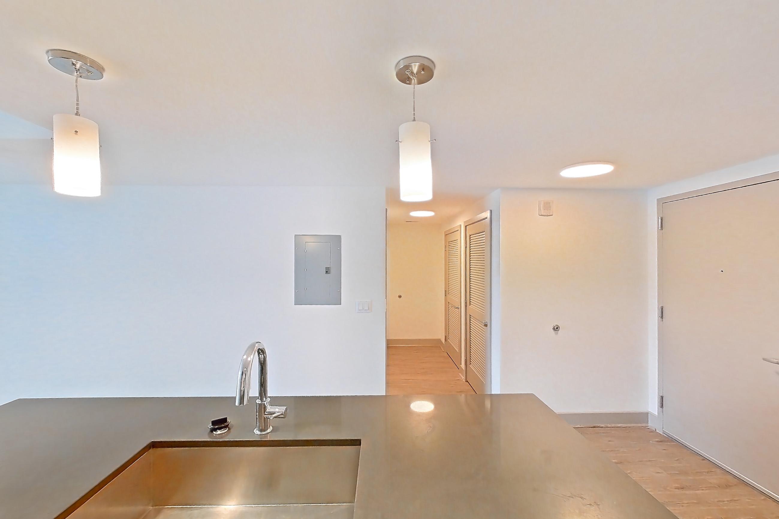 Kitchen with dark countertops, dishwasher, electric range, light countertops, light wood-finish flooring, microwave, oven/range, refrigerator, and stainless steel appliances, Apartment 3005 at Adaire