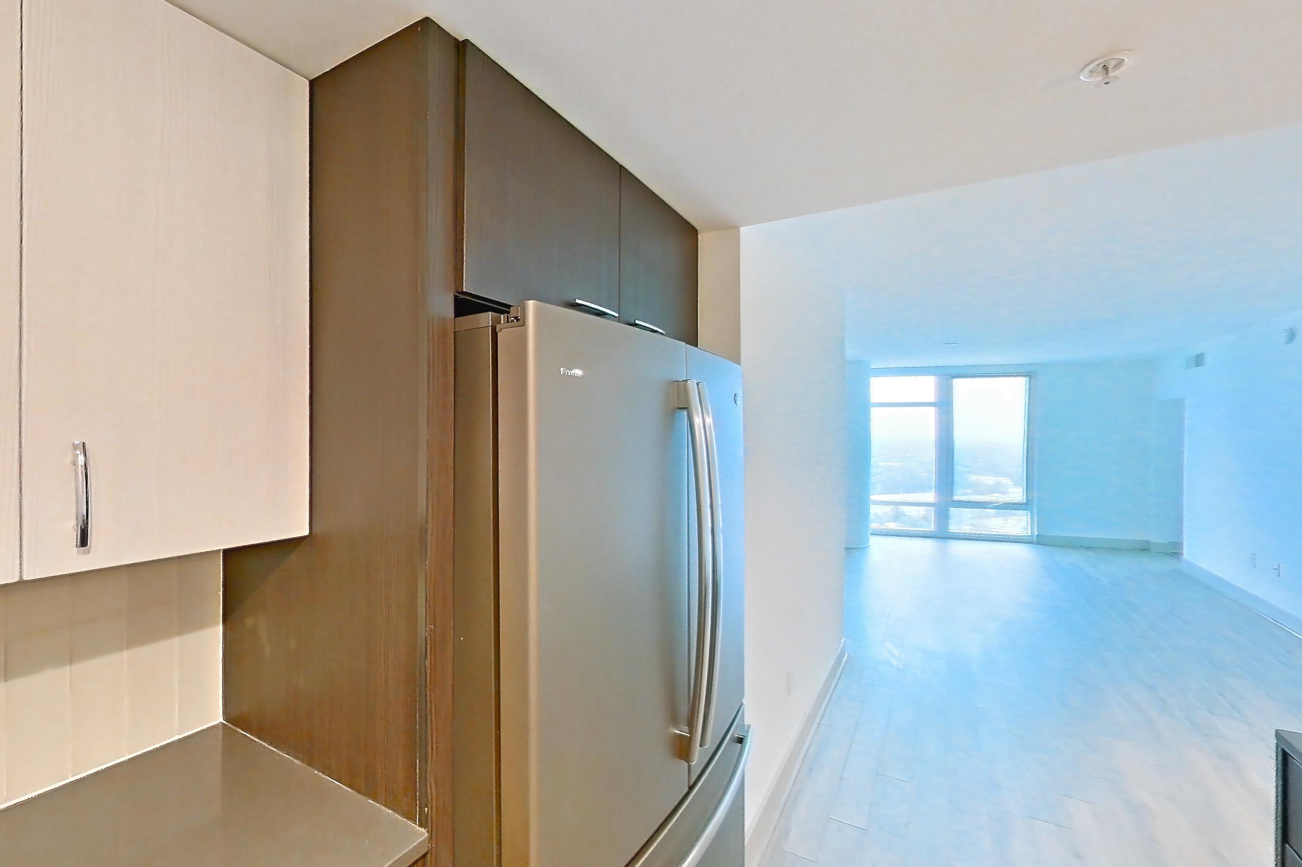 Kitchen with dark countertops, dishwasher, electric range, light countertops, light wood-finish flooring, microwave, oven/range, refrigerator, and stainless steel appliances, Apartment 3005 at Adaire