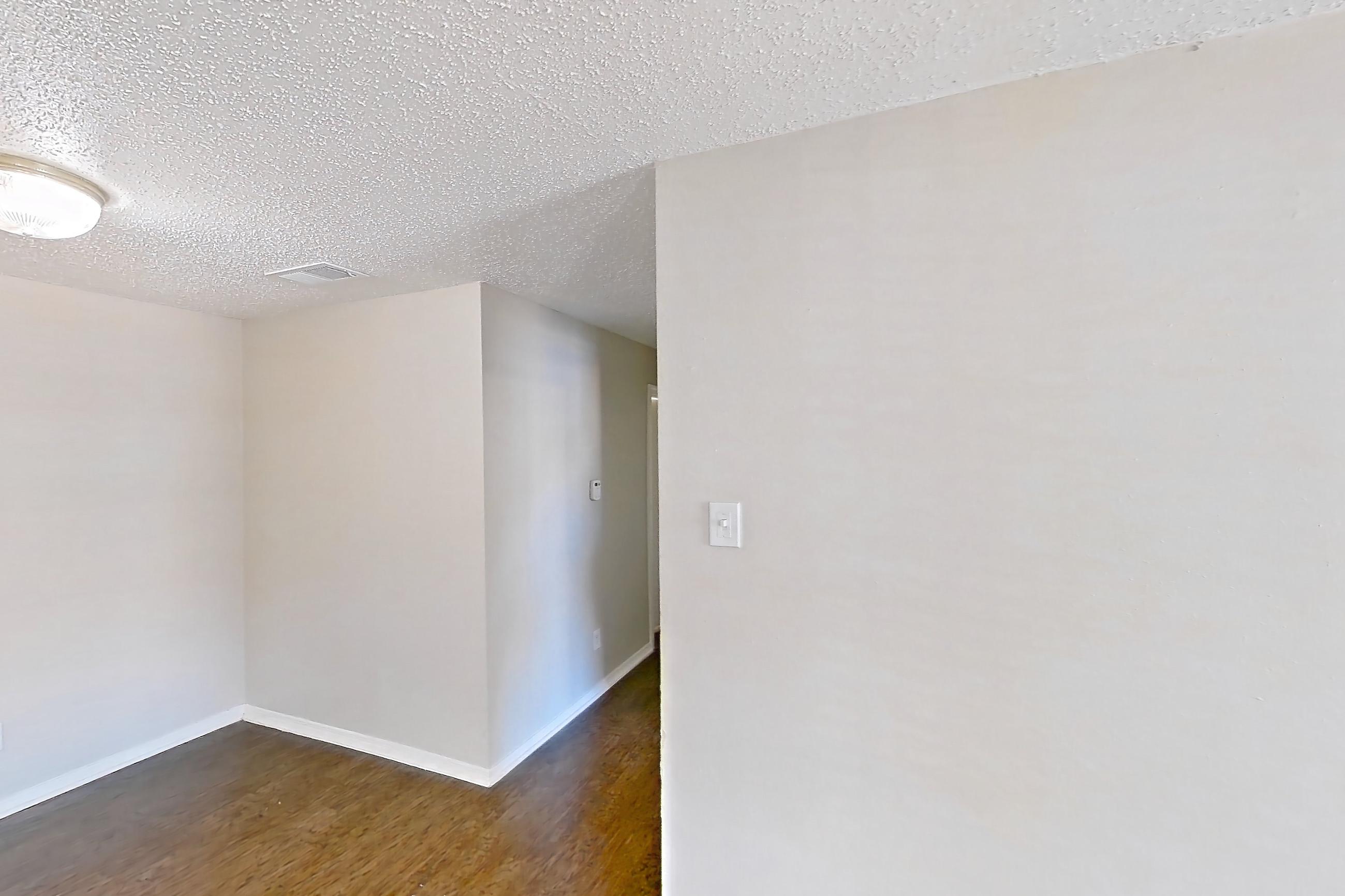Living room with dark carpet, refrigerator, and white appliances, Apartment 1324 at Arbor Creek