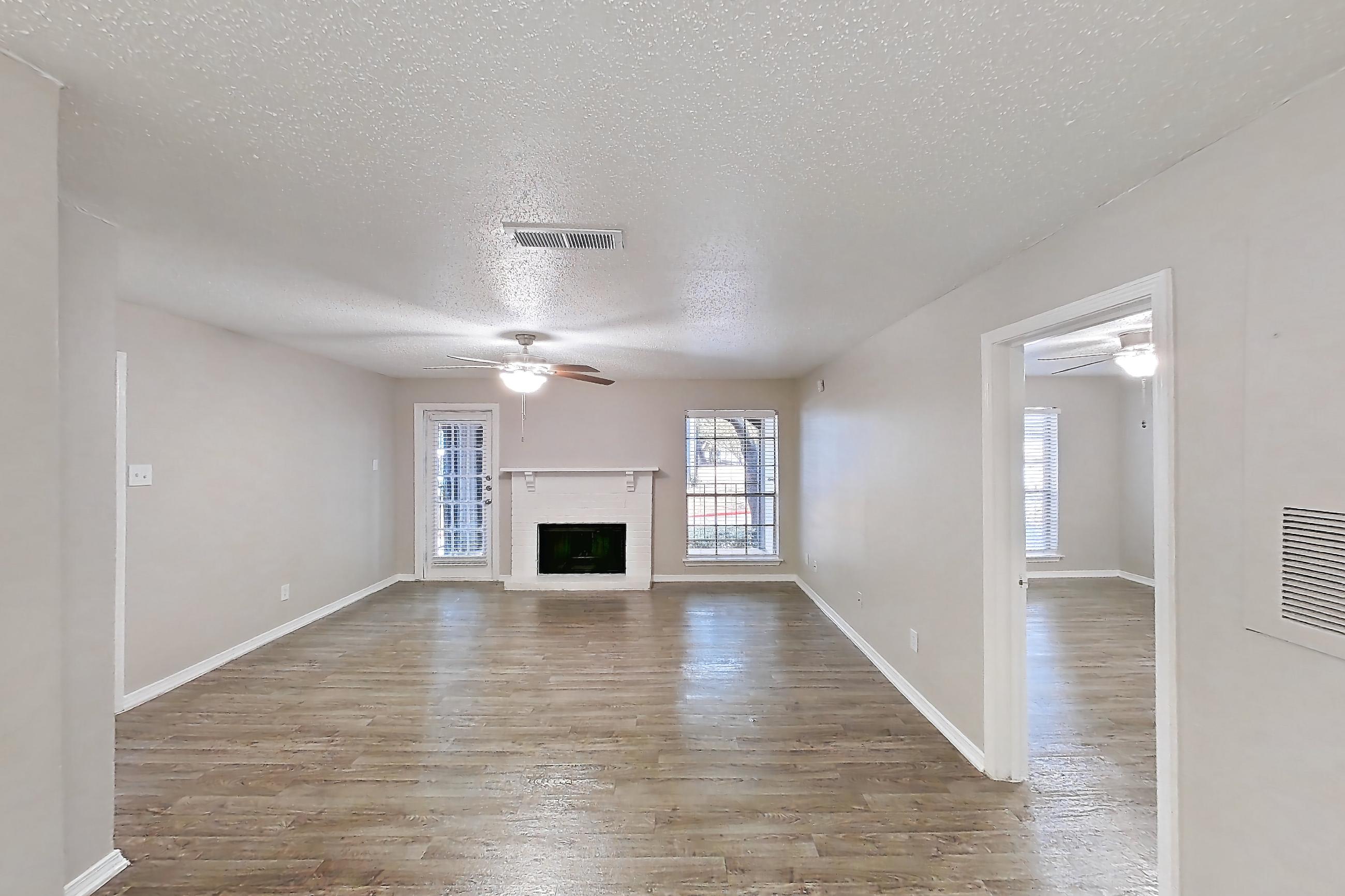 Dining room with electric range, fireplace, light countertops, light wood-finish flooring, oven/range, refrigerator, and white appliances, Apartment 122 at Arbor Creek