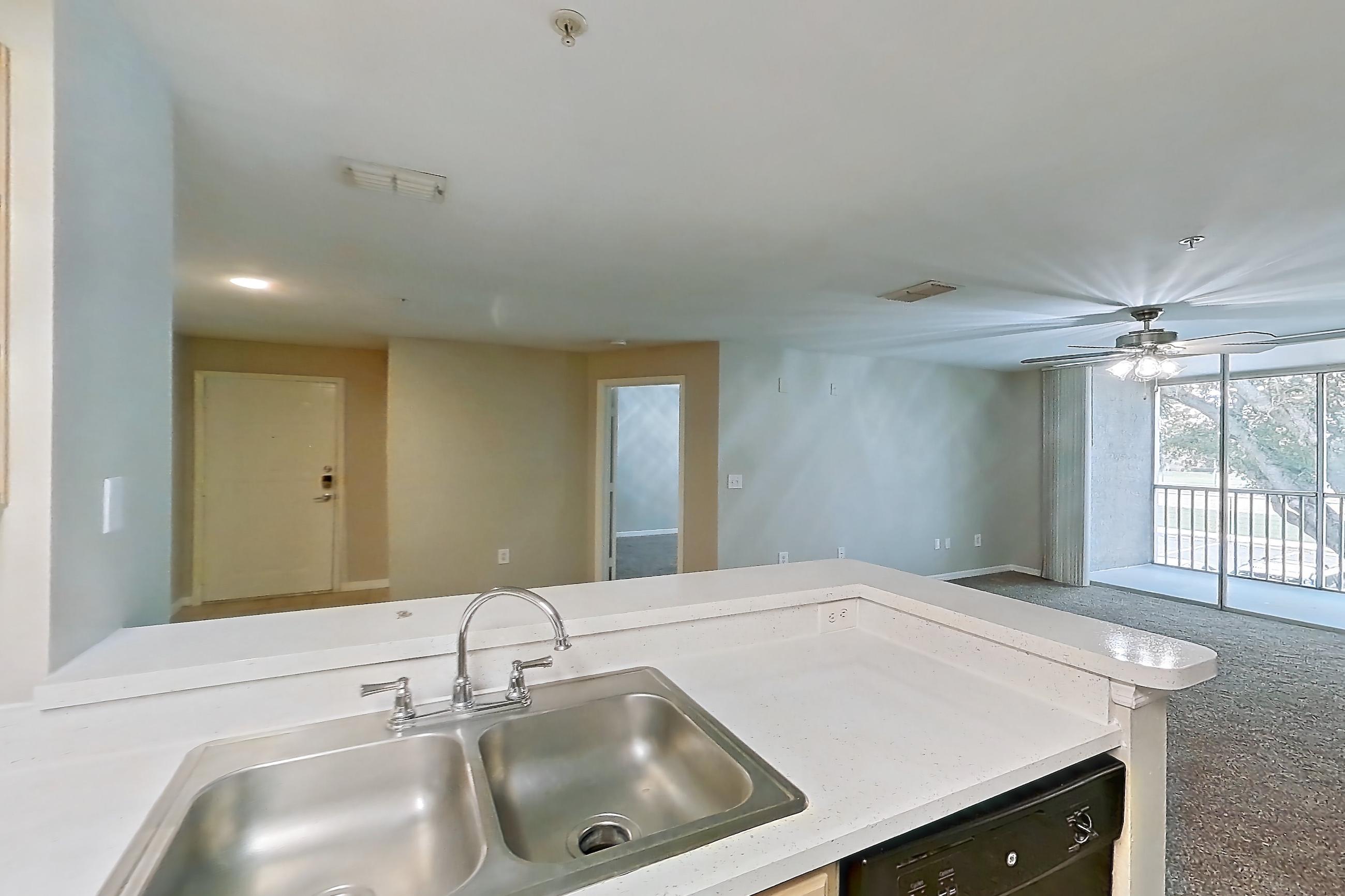 Kitchen with black appliances, dishwasher, electric range, light countertops, light stone countertops, light wood-finish flooring, oven/range, range hood, and refrigerator, Apartment 05-205 at Boot Ranch