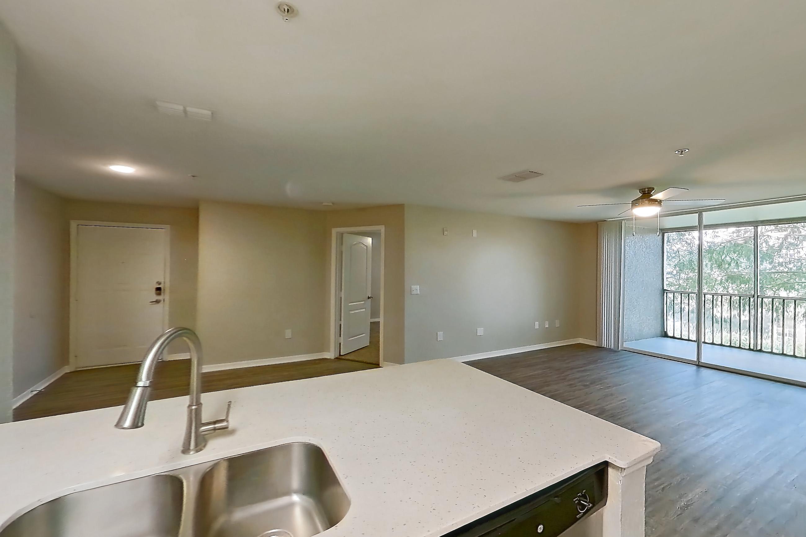 Kitchen with dishwasher, electric range, light countertops, light stone countertops, light tile flooring, light wood-finish flooring, microwave, oven/range, refrigerator, and stainless steel appliances, Apartment 07-204 at Boot Ranch