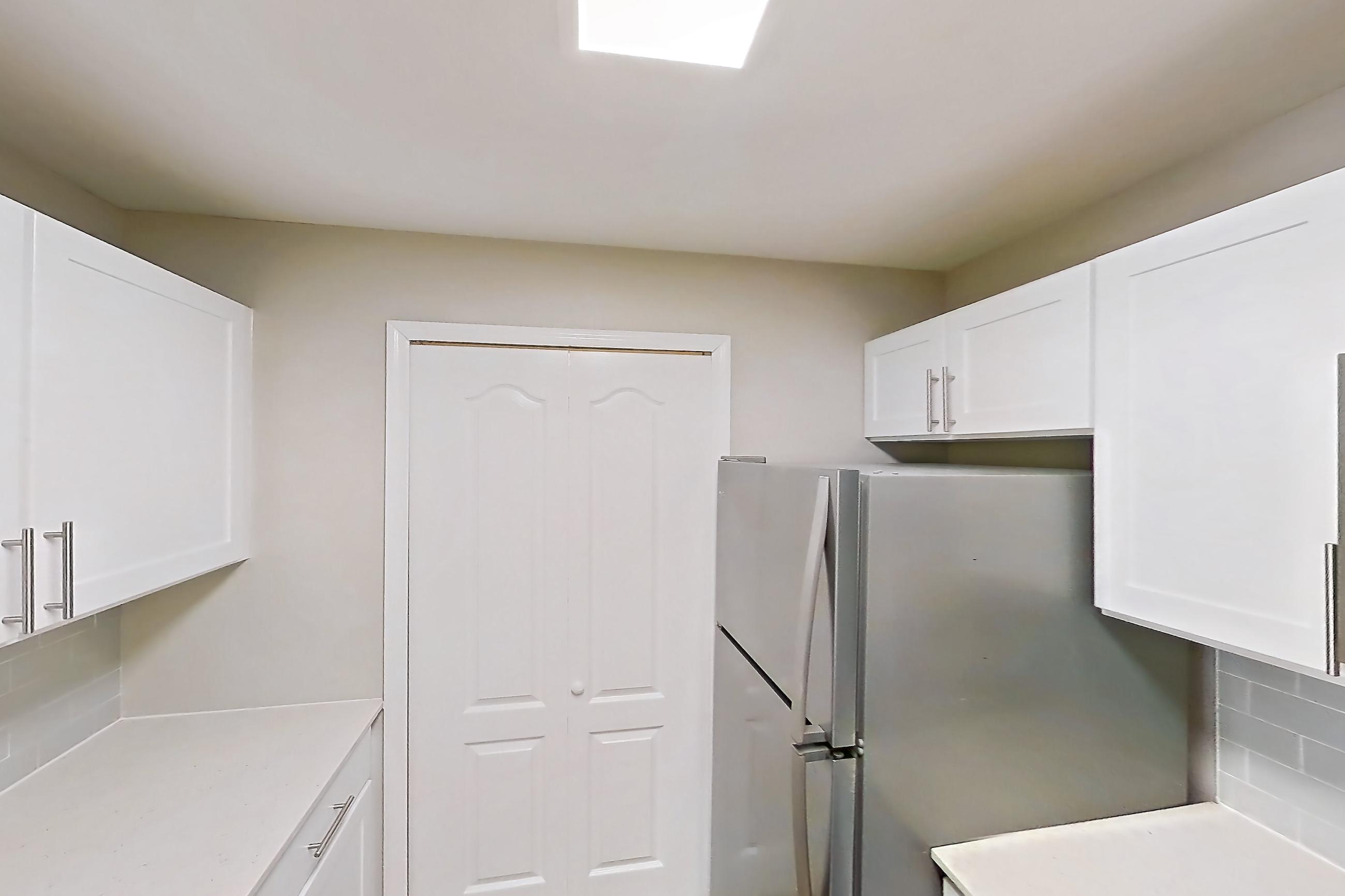 Kitchen with dishwasher, electric range, light countertops, light stone countertops, light wood-finish flooring, microwave, oven/range, refrigerator, and stainless steel appliances, Apartment 09-201 at Boot Ranch