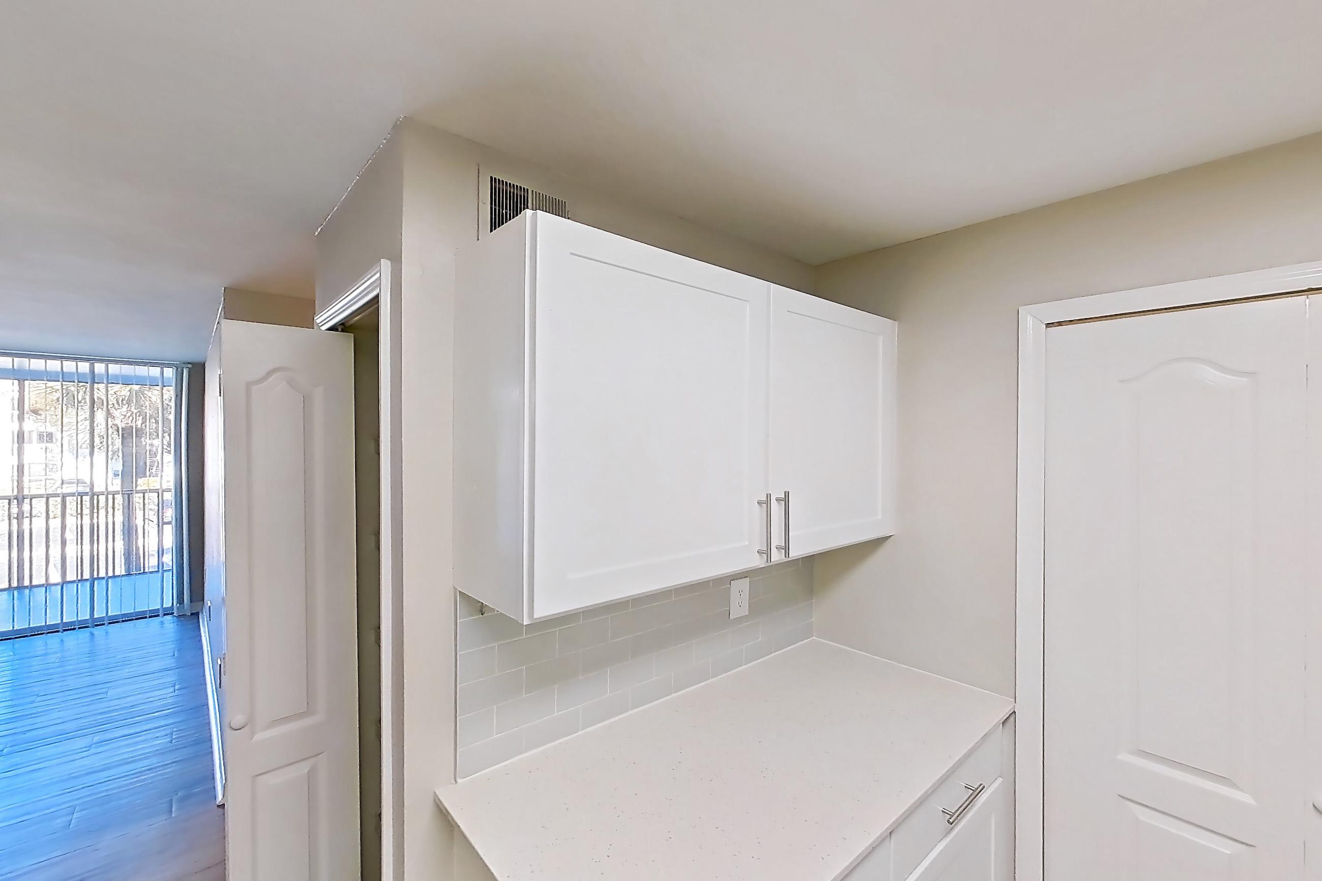 Kitchen with dishwasher, electric range, light countertops, light stone countertops, light wood-finish flooring, microwave, oven/range, refrigerator, and stainless steel appliances, Apartment 09-201 at Boot Ranch