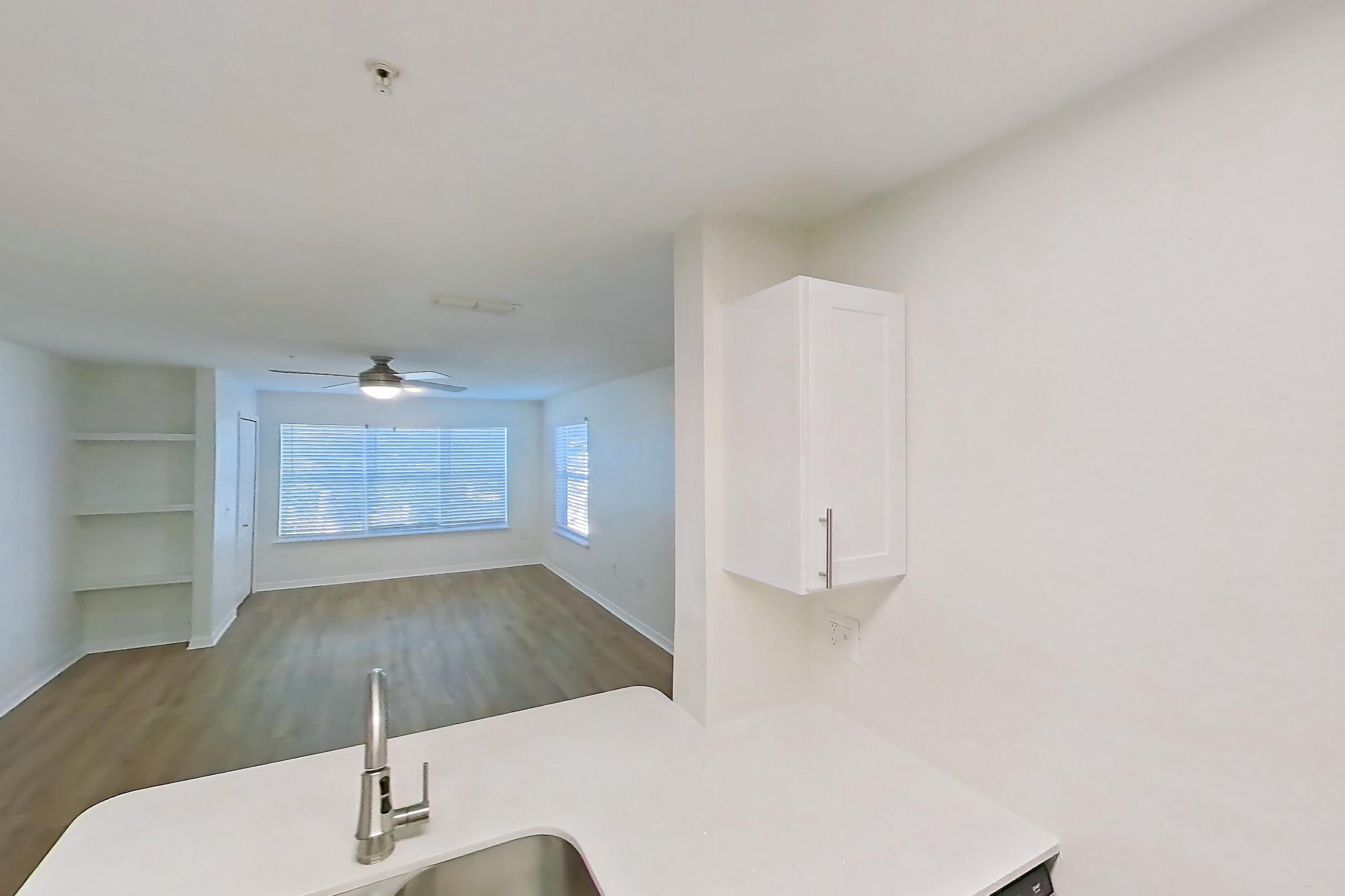 Kitchen with dishwasher, electric range, light countertops, light stone countertops, light wood-finish flooring, microwave, oven/range, refrigerator, and stainless steel appliances, Apartment 14-204 at Boot Ranch