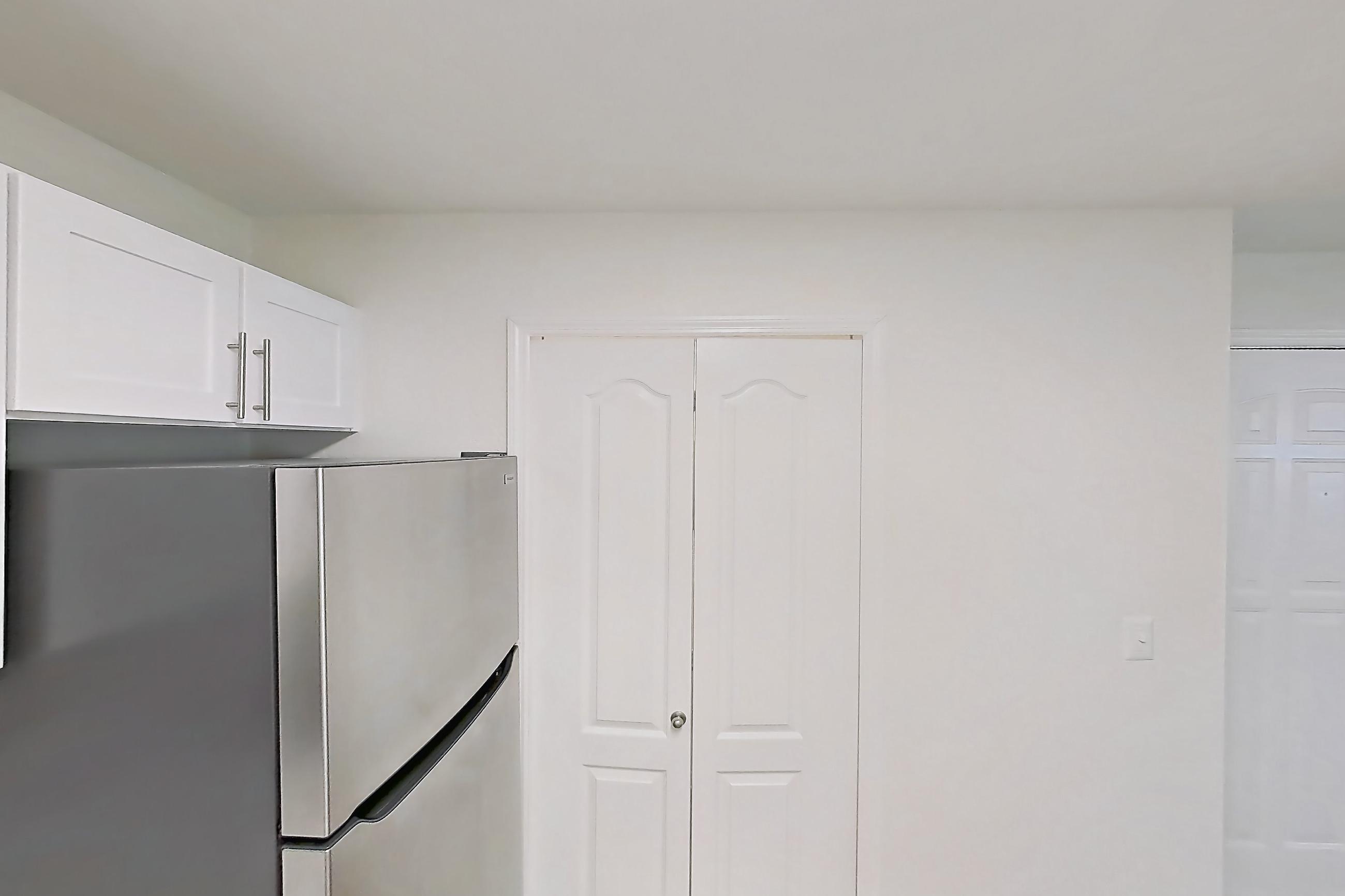 Kitchen with dishwasher, electric range, light countertops, light stone countertops, light wood-finish flooring, microwave, oven/range, refrigerator, and stainless steel appliances, Apartment 14-204 at Boot Ranch