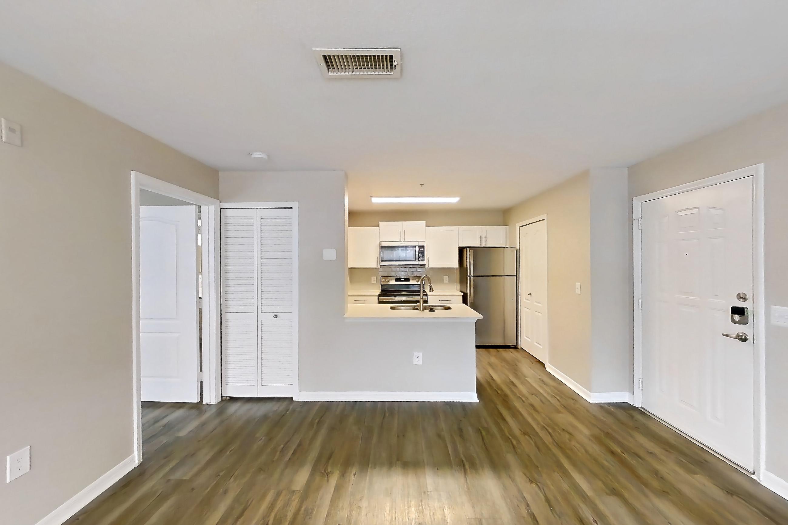 Living space with dark wood-finish flooring, electric range, oven/range, refrigerator, and stainless steel appliances, Apartment 15-105 at Boot Ranch