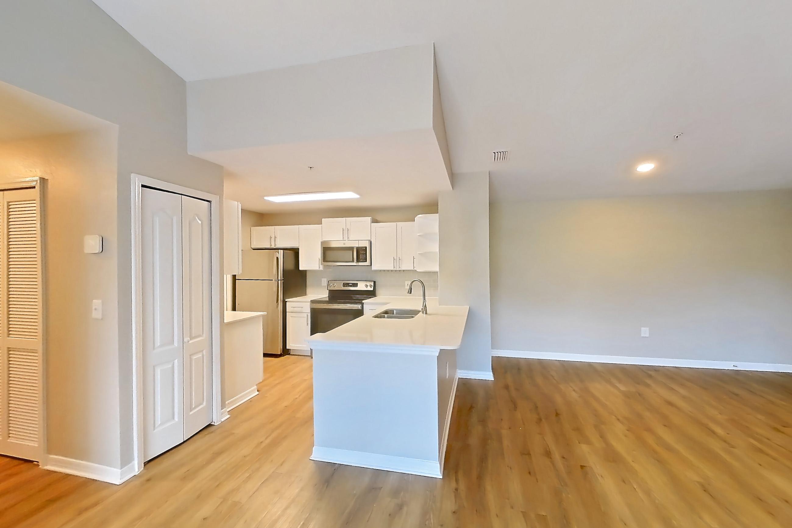 Living space with electric range, light countertops, light wood-finish flooring, oven/range, refrigerator, stainless steel appliances, and white appliances, Apartment 16-301 at Boot Ranch